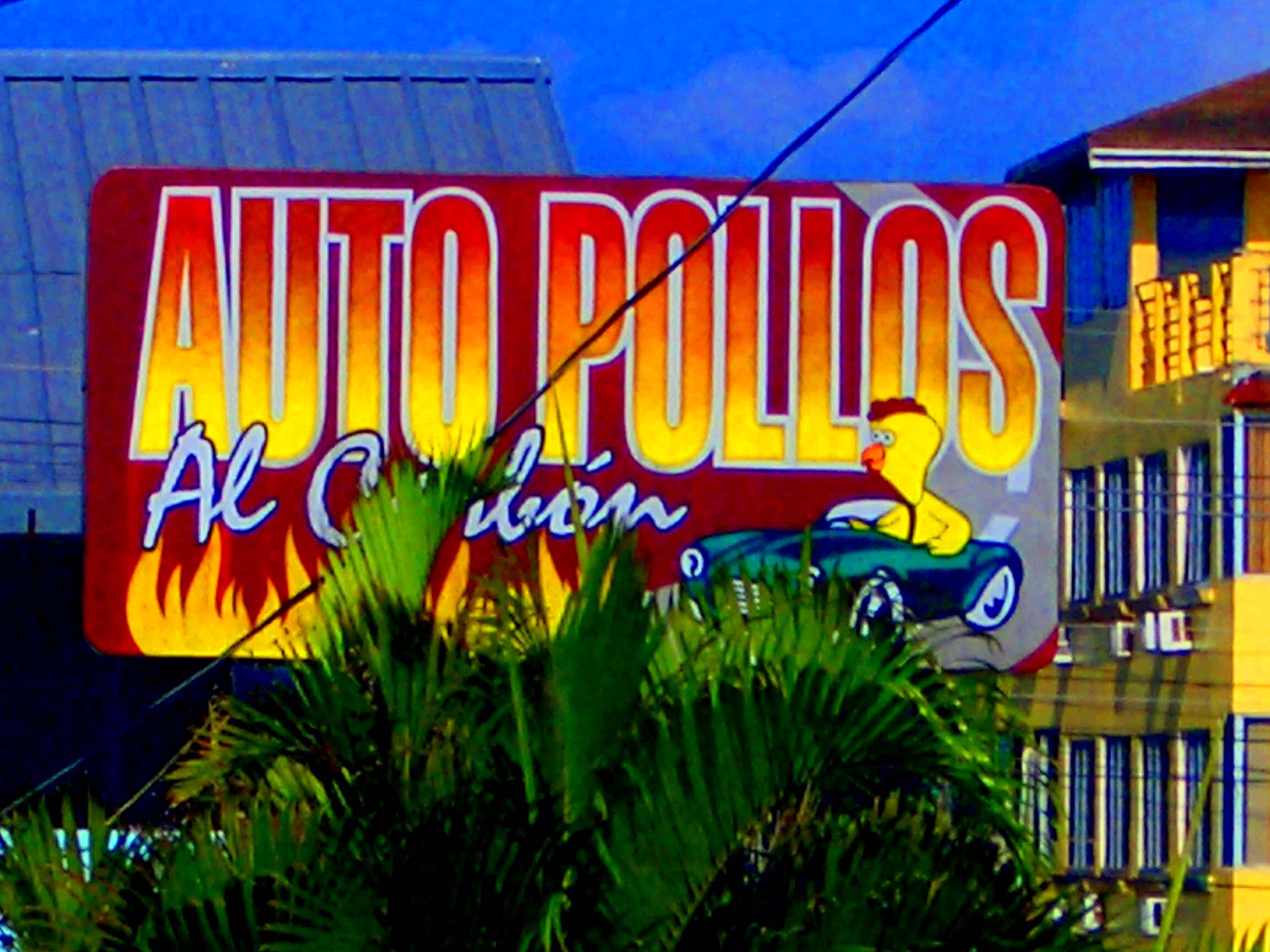 The sign for the Auto Pollos al Carbón restaurant in Tela, Honduras.
