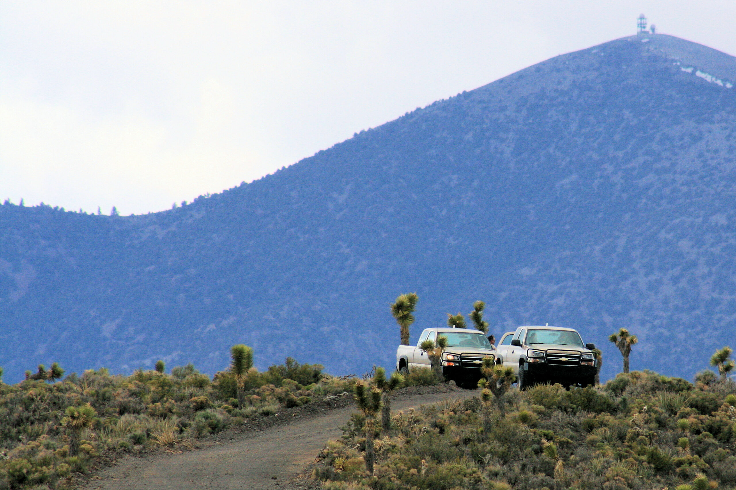 Area 51 security officers sit in trucks on a ridge watching for trespassers.