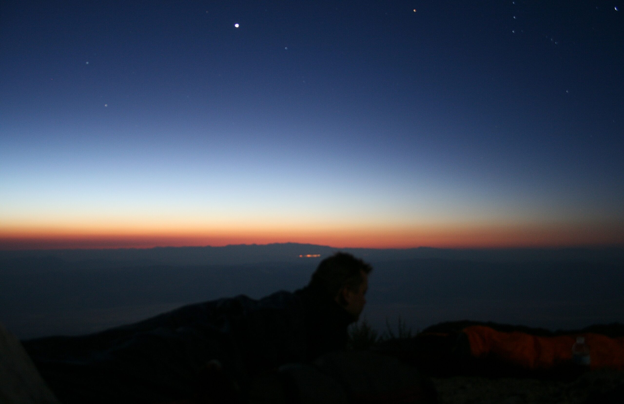 Rich watches the sunrise from his sleeping bag at the top of Death Valley's Telescope Peak.