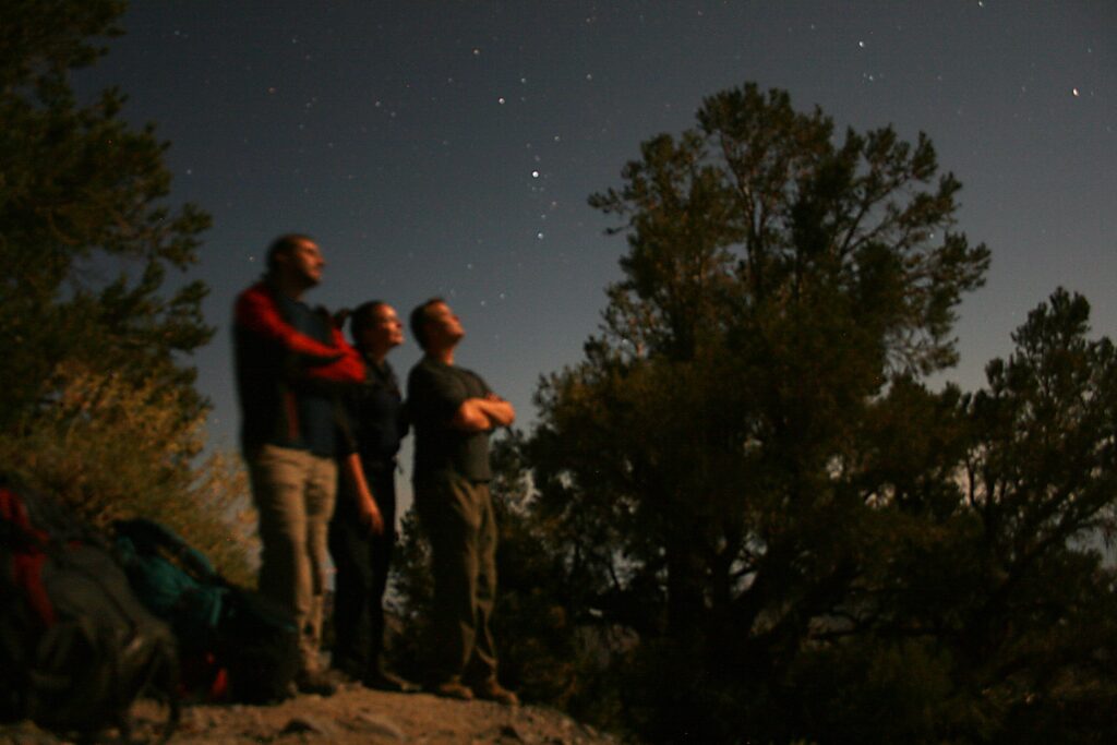A 30-second exposure reveals hikers gazing at the moon near Death Valley's Telescope Peak.