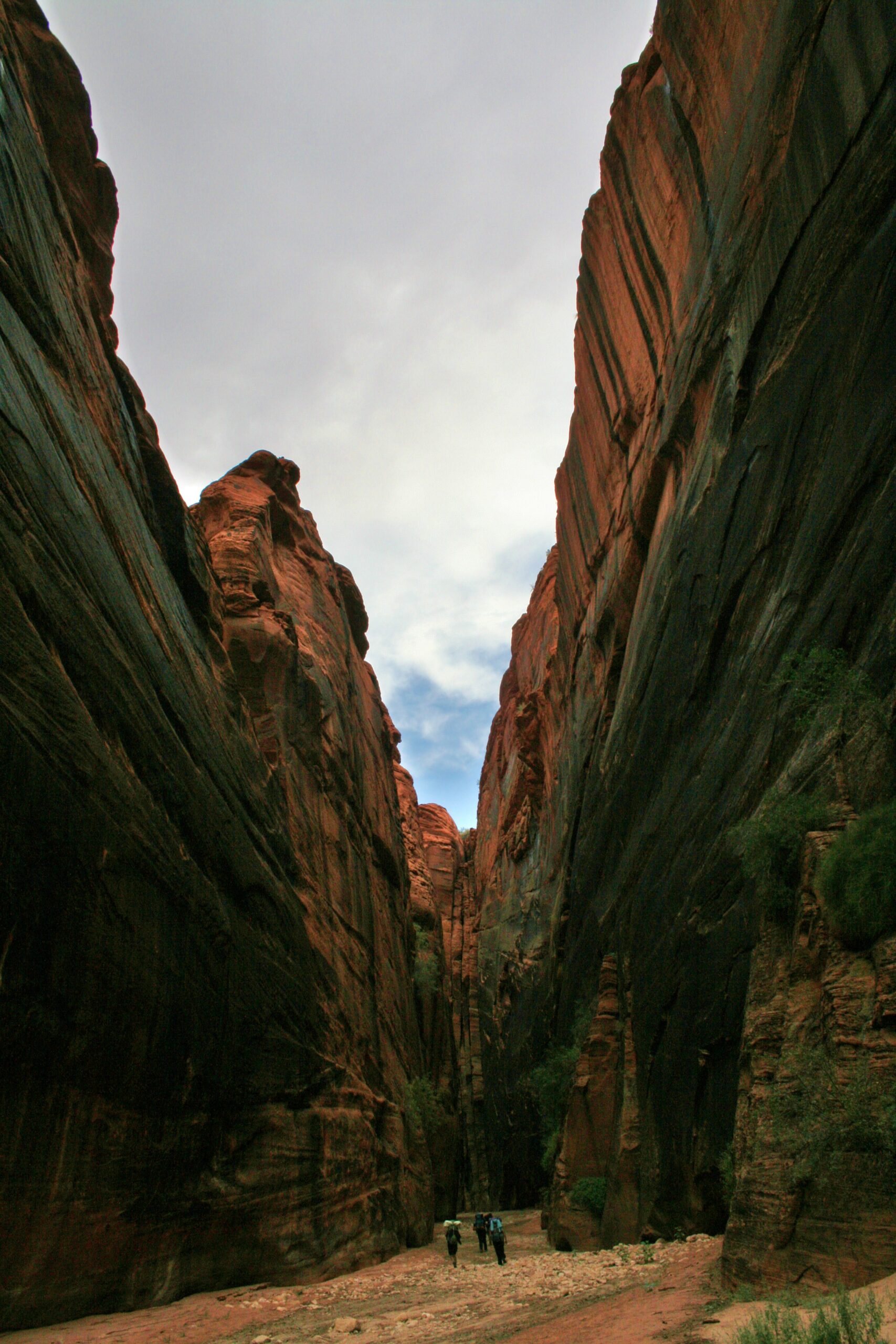 Hikers make their way through a particularly wide section of Buckskin Gulch.
