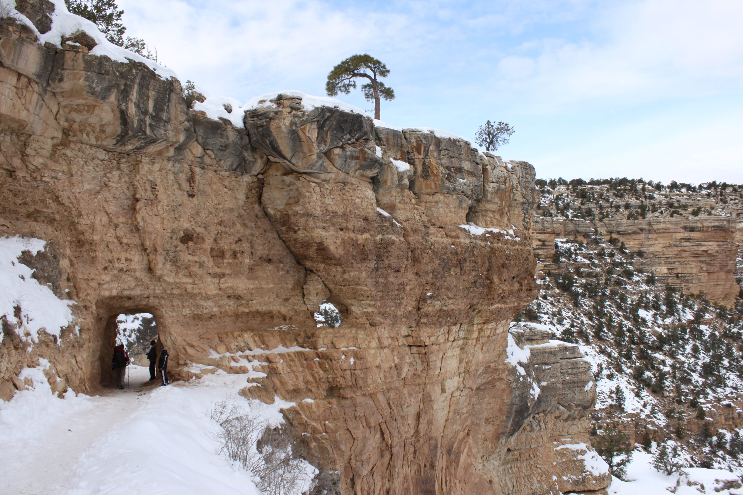 Hikers stand in a rock tunnel on the Grand Canyon's Bright Angel Trail.