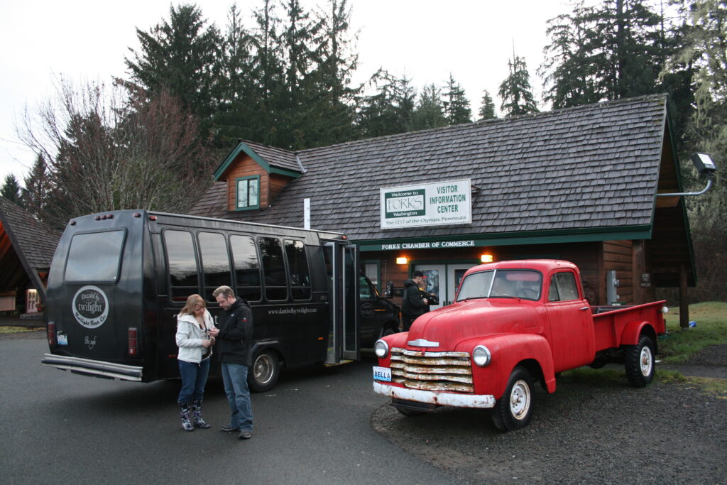 Twilight fans stand in front of the Forks Chamber of Commerce and a replica of Bella's 1953 Chevy pickup truck.