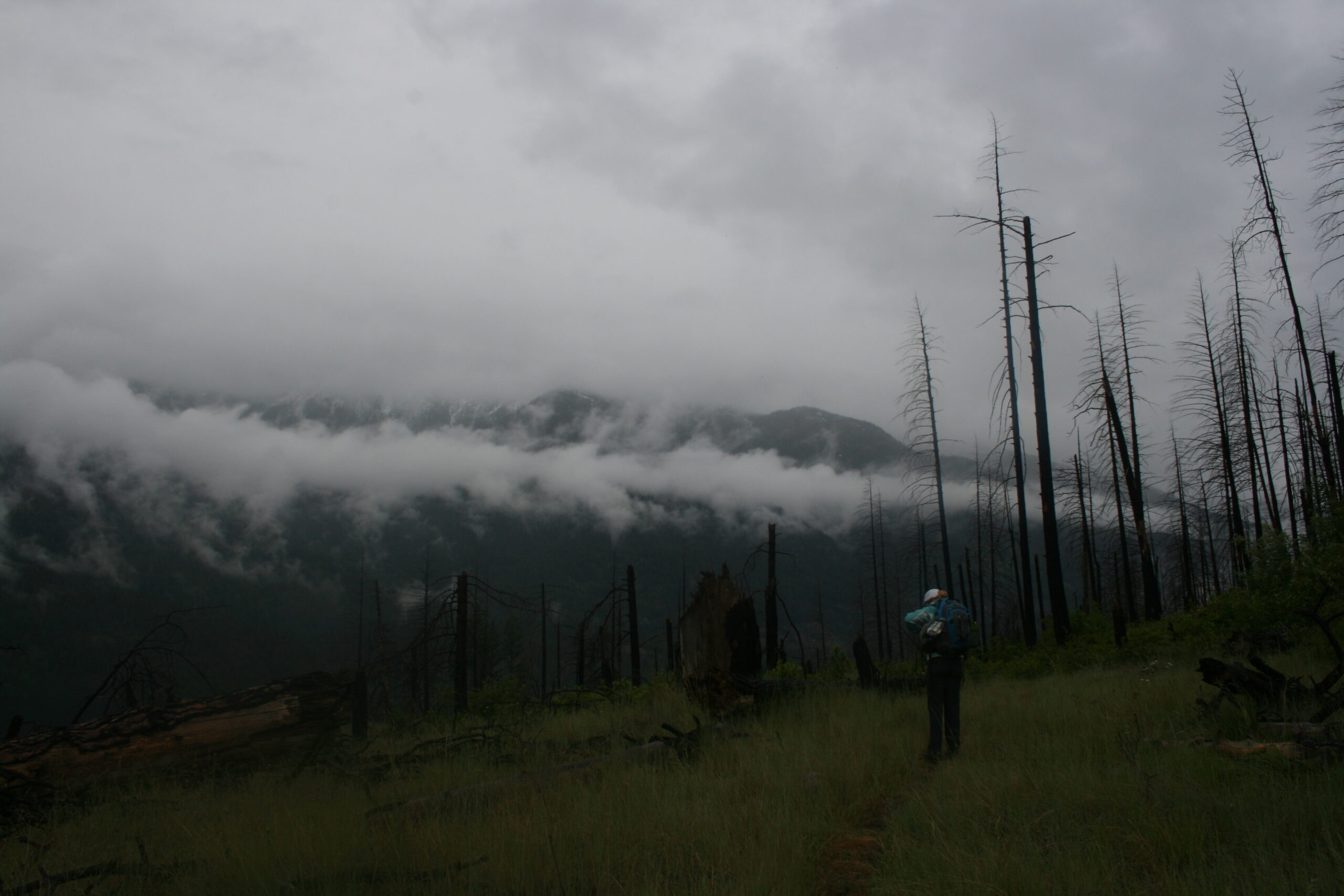 A hiker walks below clouds near Lake Chelan.