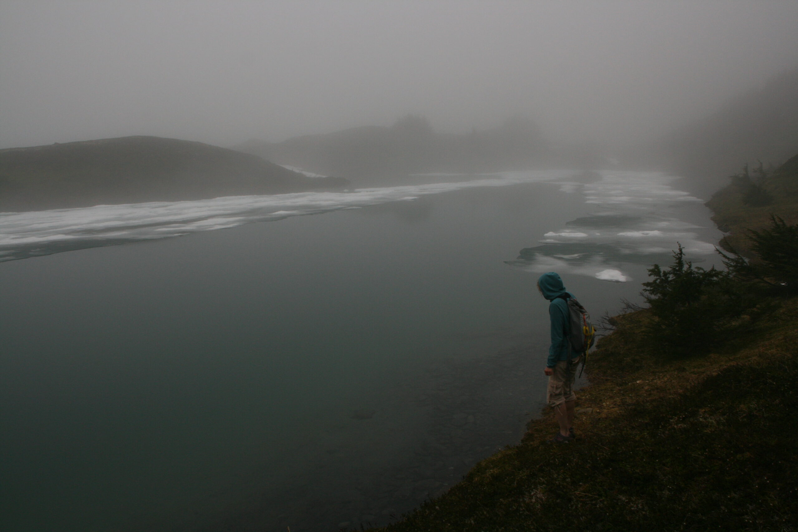 A hiker stands at the edge of Lost Lake near Seward, Alaska.