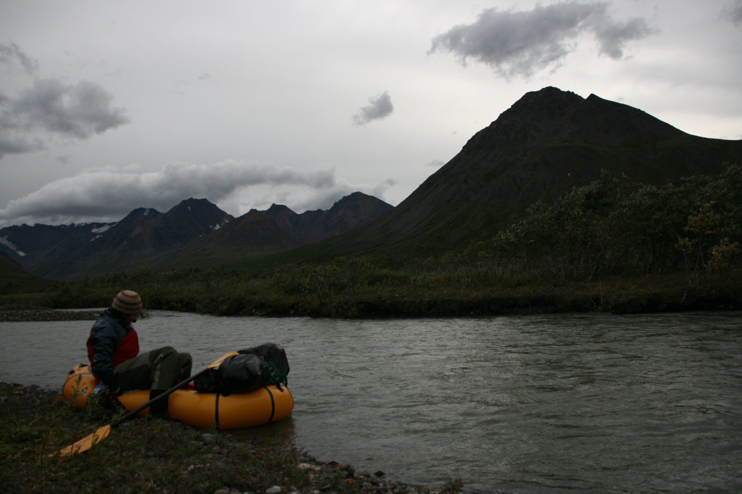 Mitch gets into a packraft on the shore of the Sanctuary River.