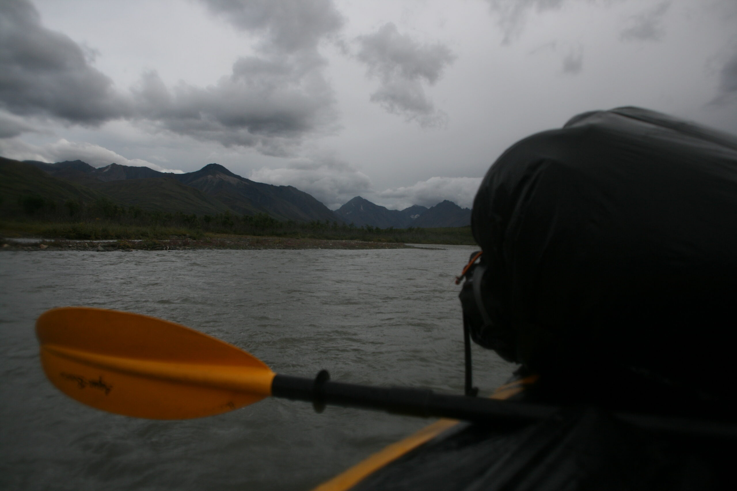 Clouds gather over Denali's Sanctuary River during a packrafting trip.