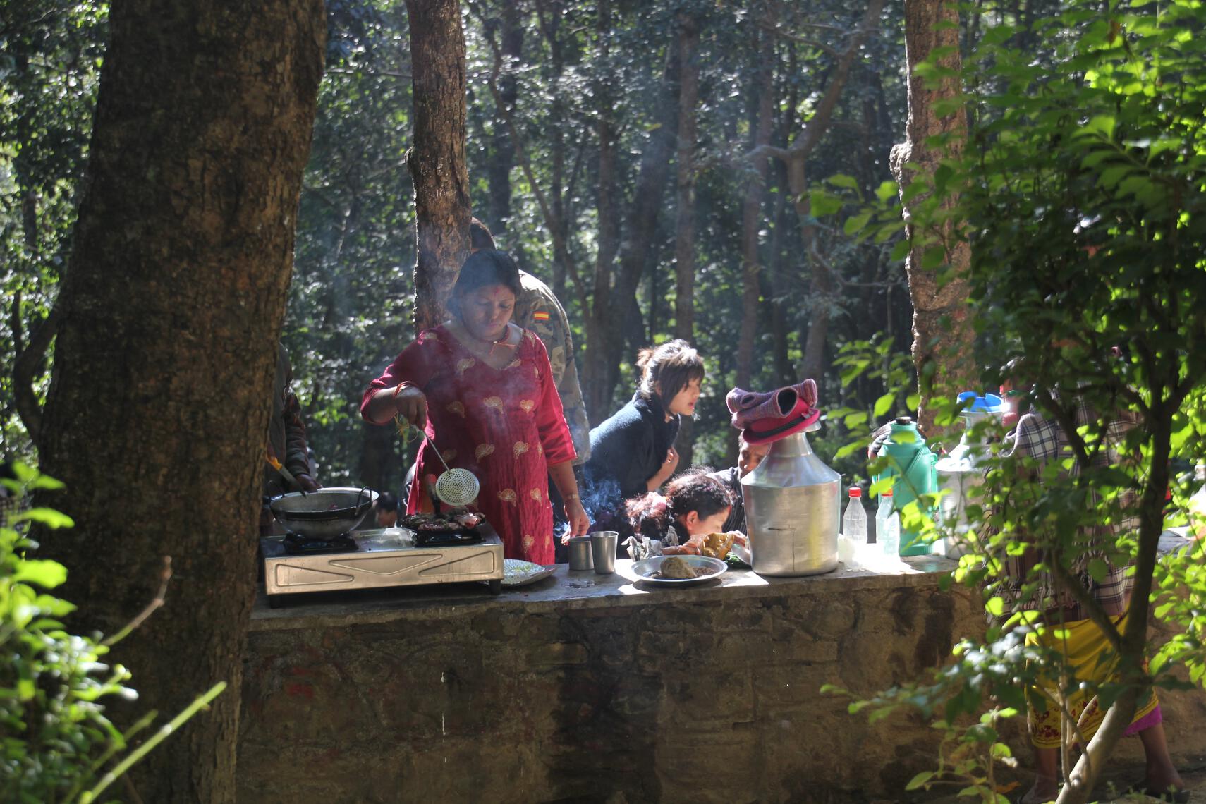 A Nepalese family roasts meat for a picnic following a sacrifice to Kali.