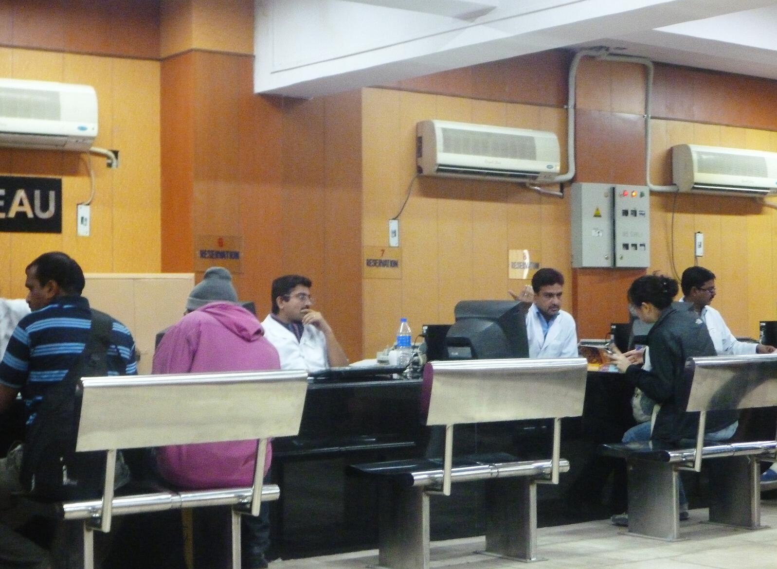 Men inexplicably wearing white doctor coats man the foreigners-only ticket office in the New Delhi train station.