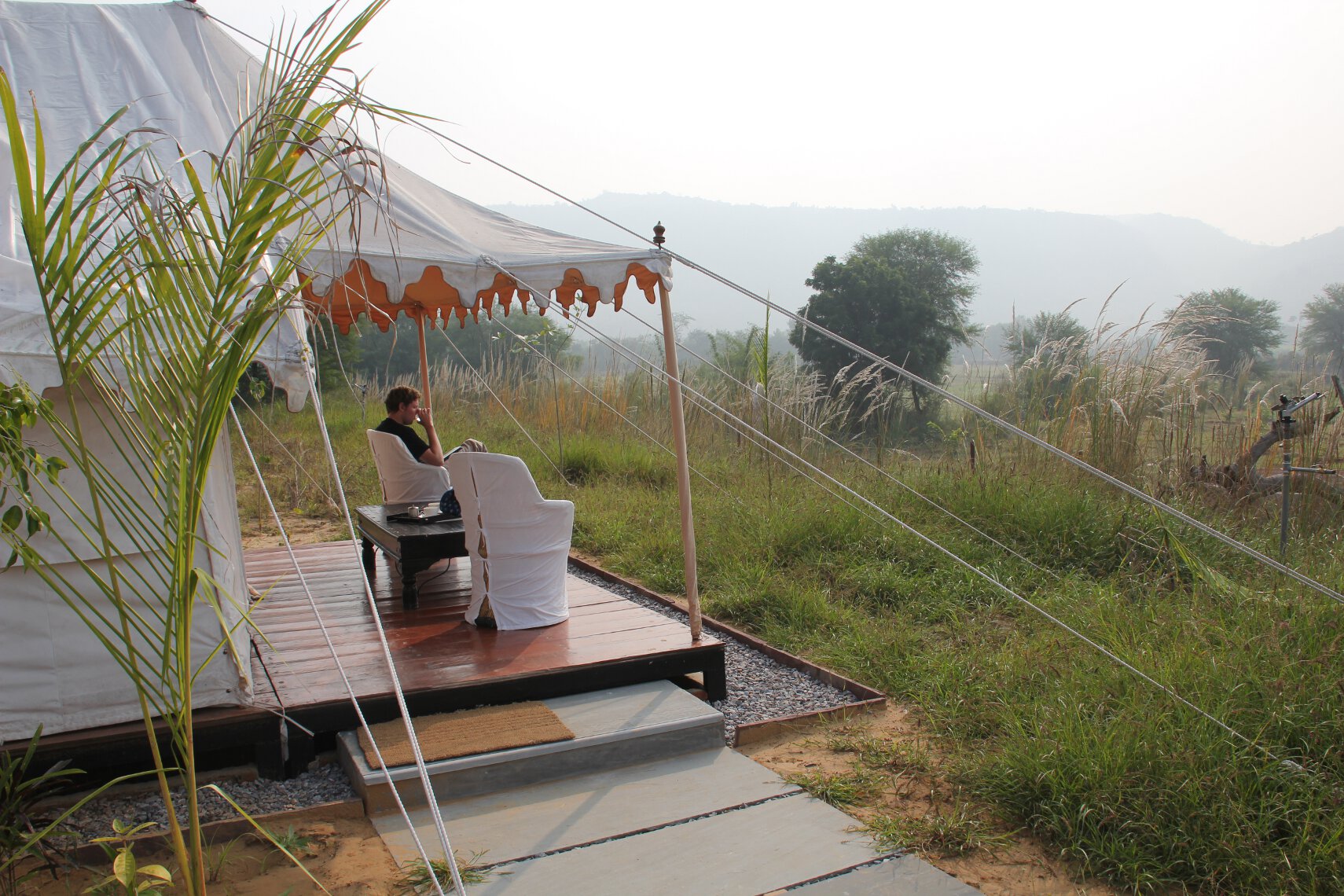 A tourist sits outside his luxury tent at Khem Villas near Ranthambore National Park, India.