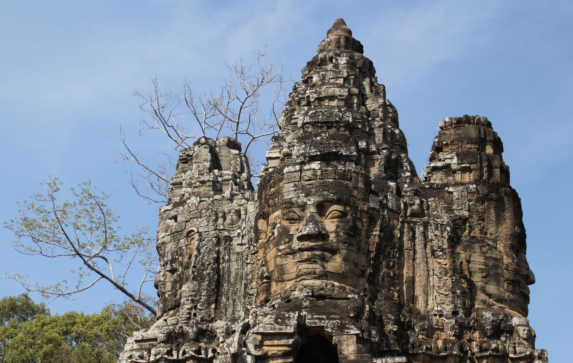 A stone face stands guard above one of the entrance gates to Angkor.