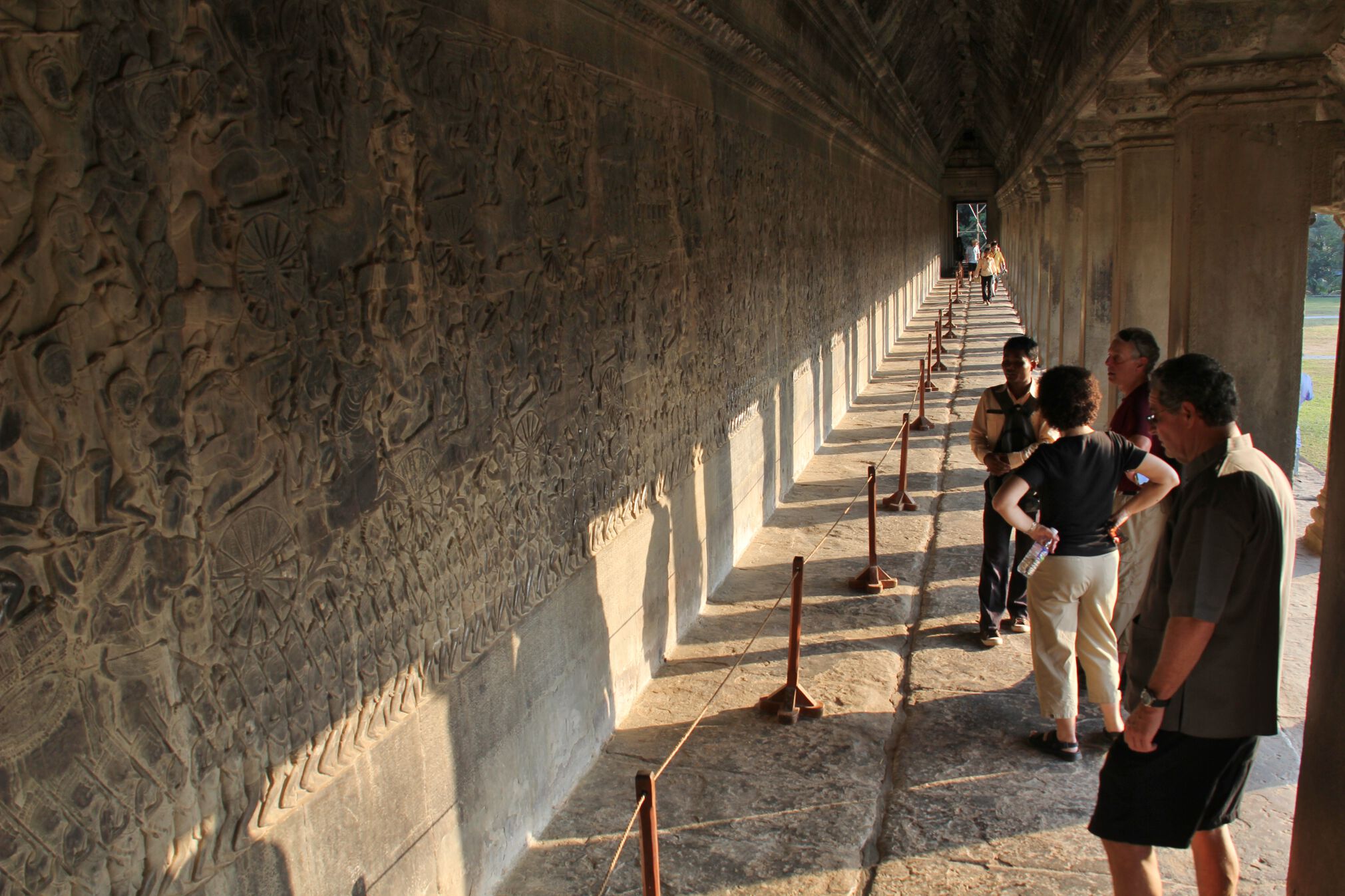 Tourists look at the beautiful and intricate bas-reliefs in Angkor Wat.