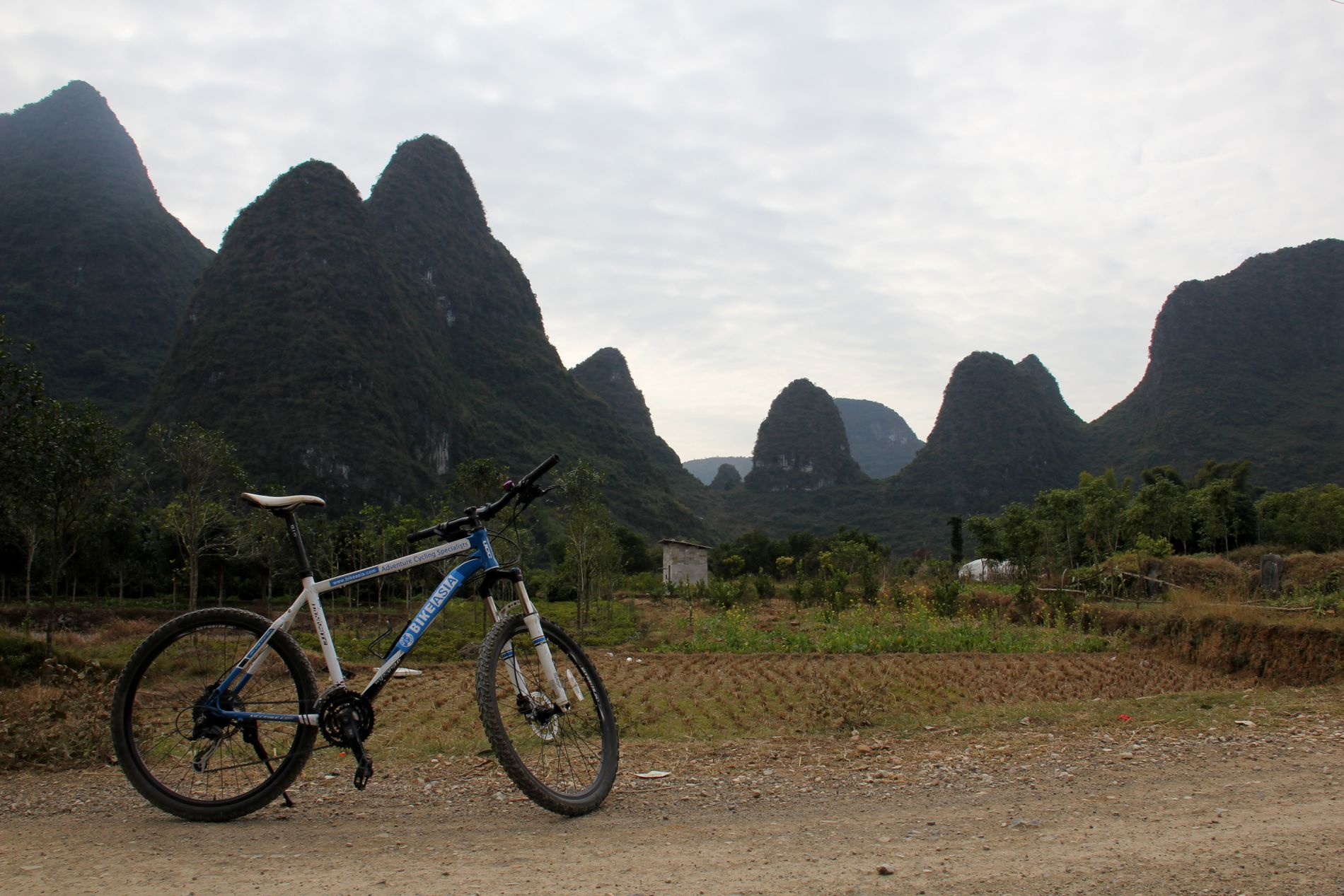 A bicycle sits in front of the otherworldy karsts of Yángshuò, GuÄƒngxÄ«, China.