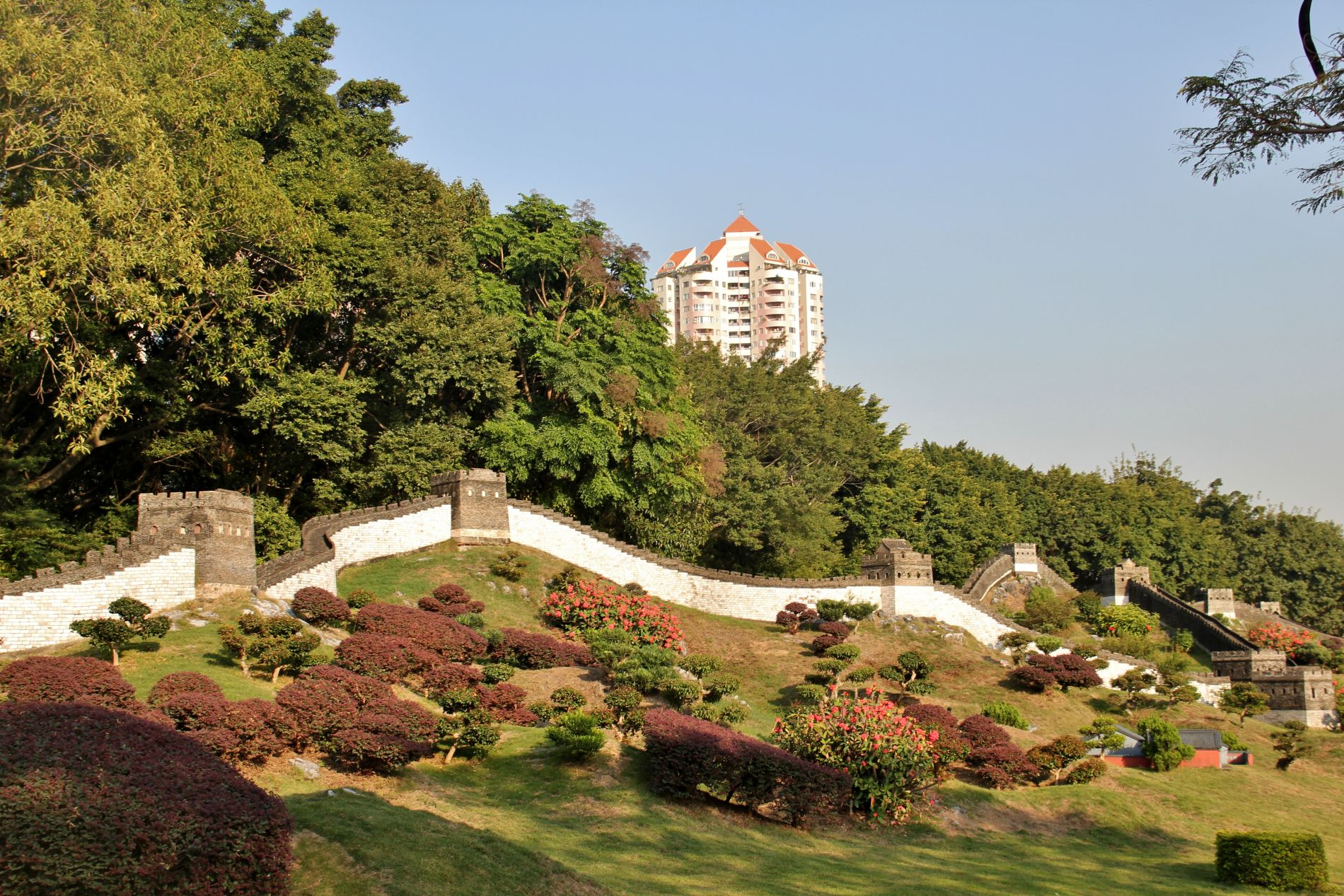 Shenzhen apartment buildings tower over a miniature reproduction of the Great Wall of China at Splendid China in Shenzhen.