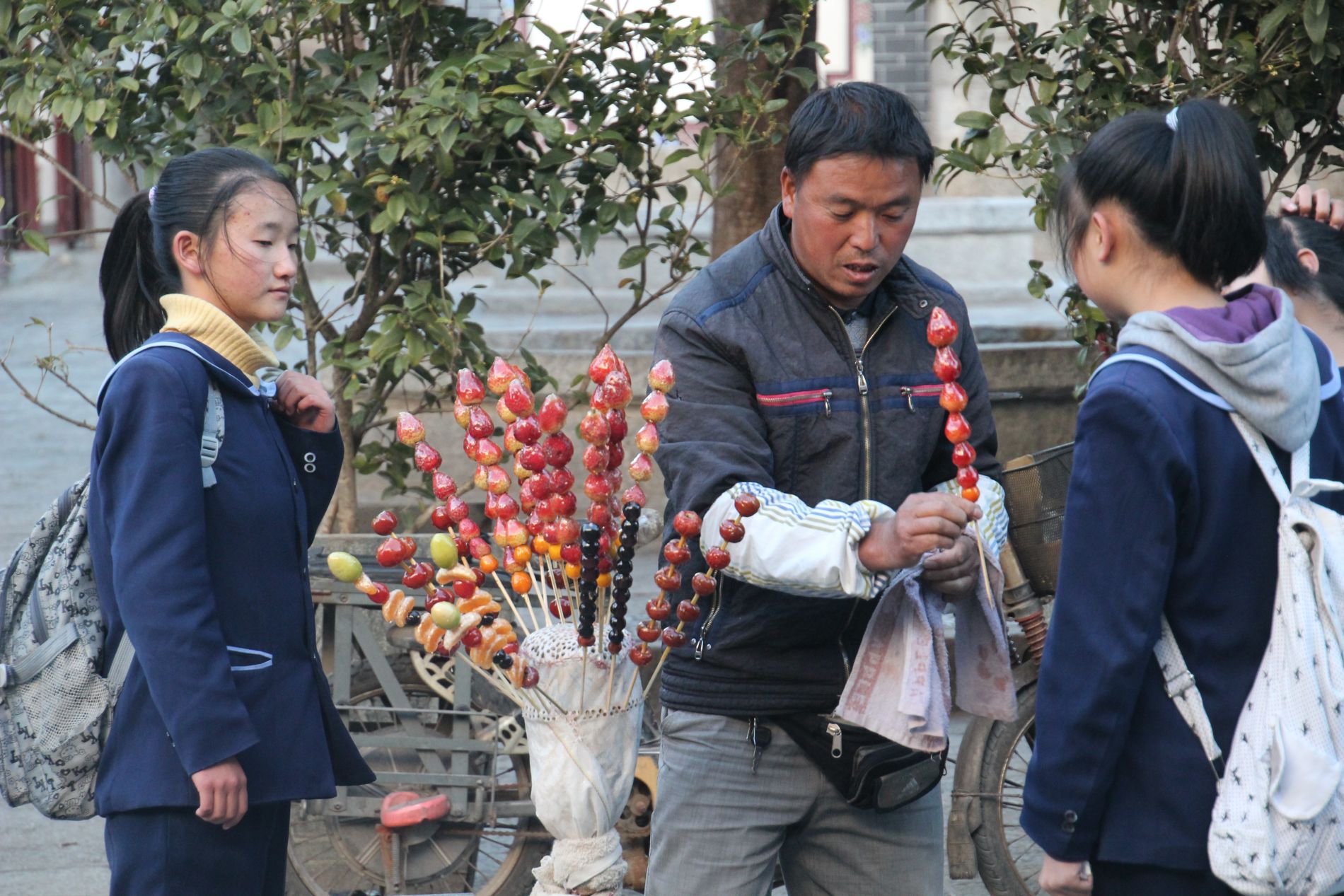 A man sells sugar-covered strawberries in DàlÇ??, China.