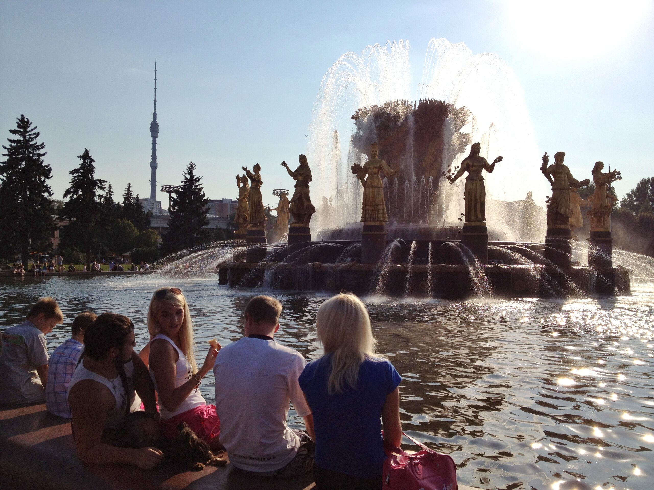 Muscovites sit on the edge of a fountain at the All-Russia Exhibition Centre (VVC).