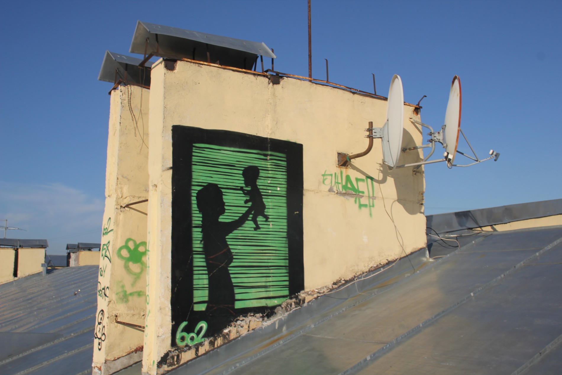 A mural seen on a roof in St. Petersburg, Russia depicts a woman holding an infant.