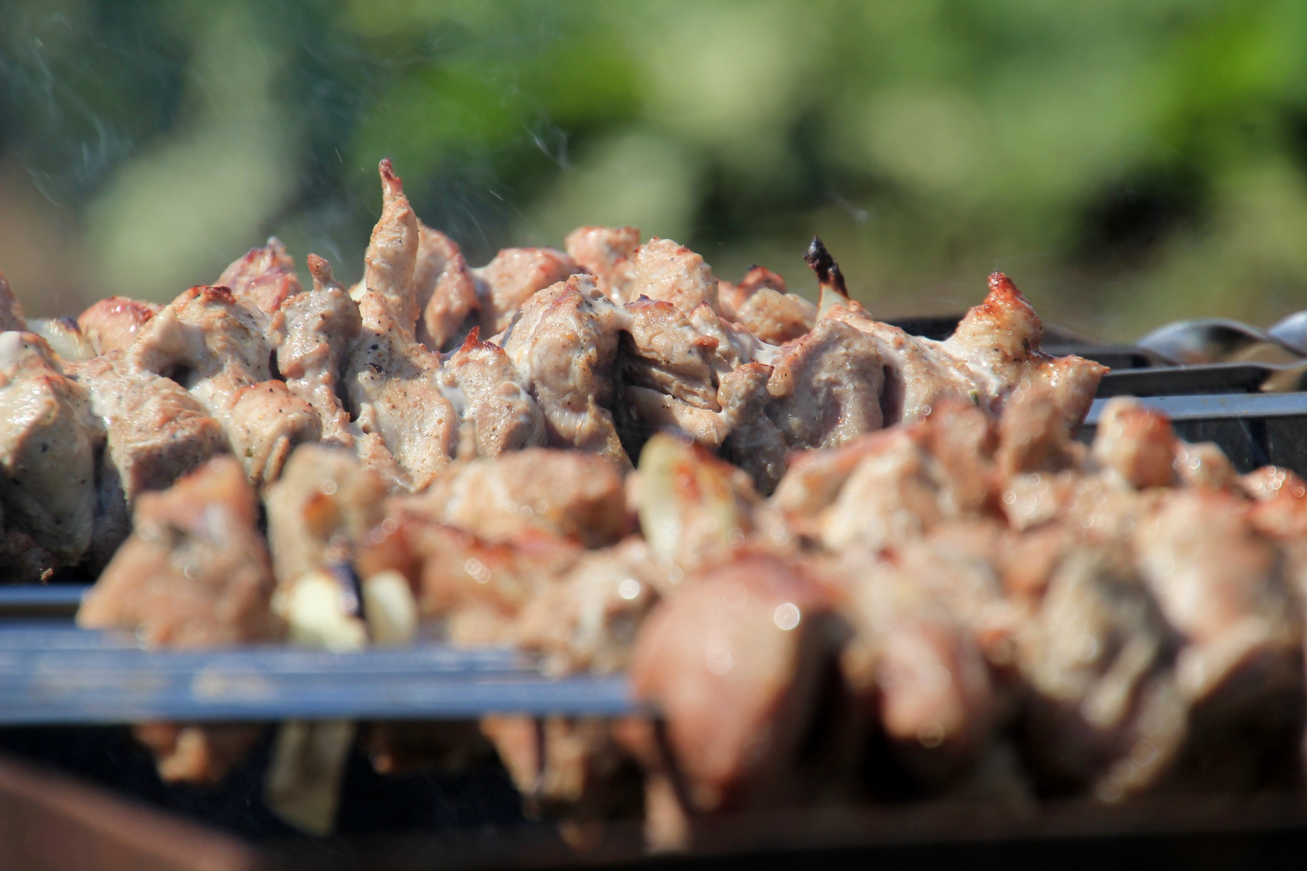 Russian shashlik cooks on a grill outside a dacha.