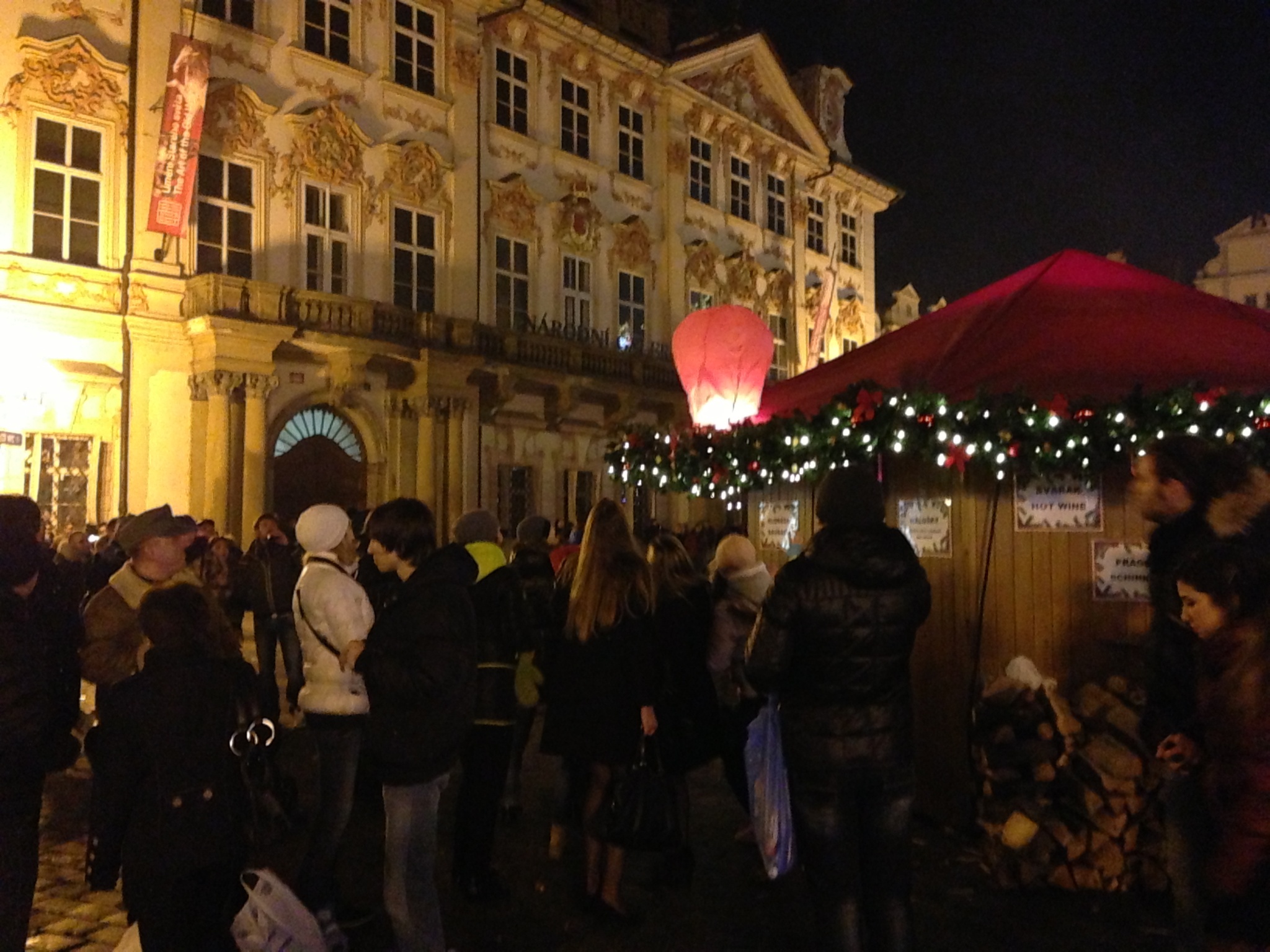 A lit Chinese skylantern settles onto a vendor's booth's awning in Prague's Old Town Square.