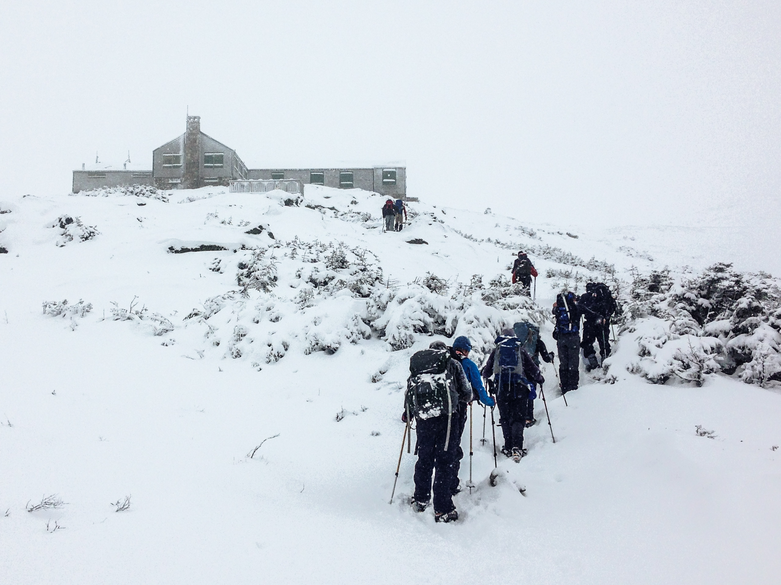 Hikers catch a glimpse of the Lake of the Clouds Hut below Mount Washington&#039;s summit.