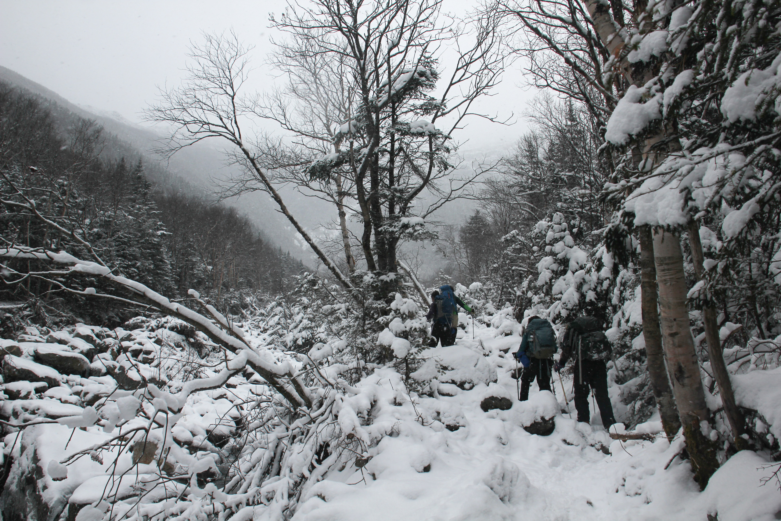 Hikers hike up Mount Washington in deep snow.