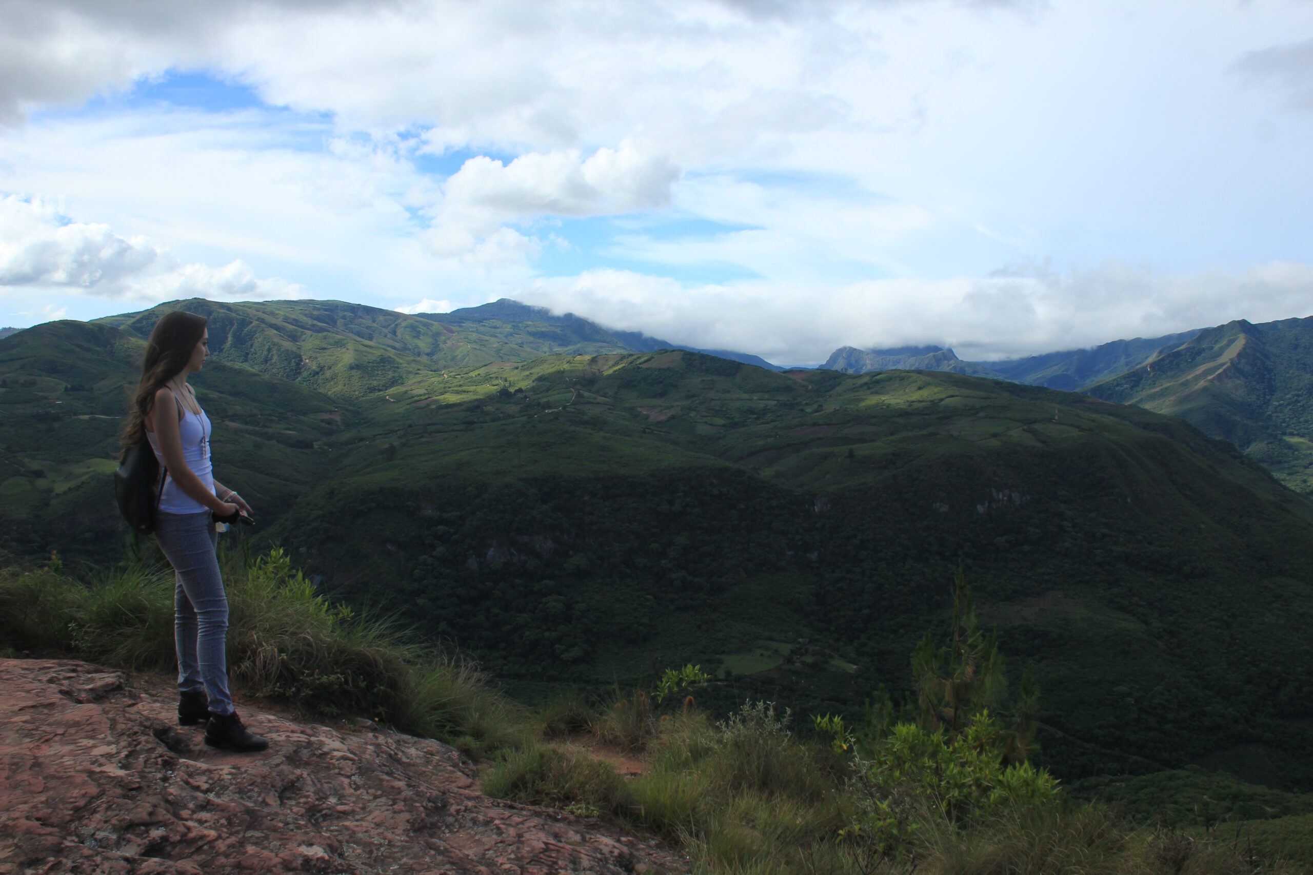 A Bolivian woman looks out at the Andes Mountains surrounding the El Fuerte de Samaipata pre-Incan ruins in Bolivia.