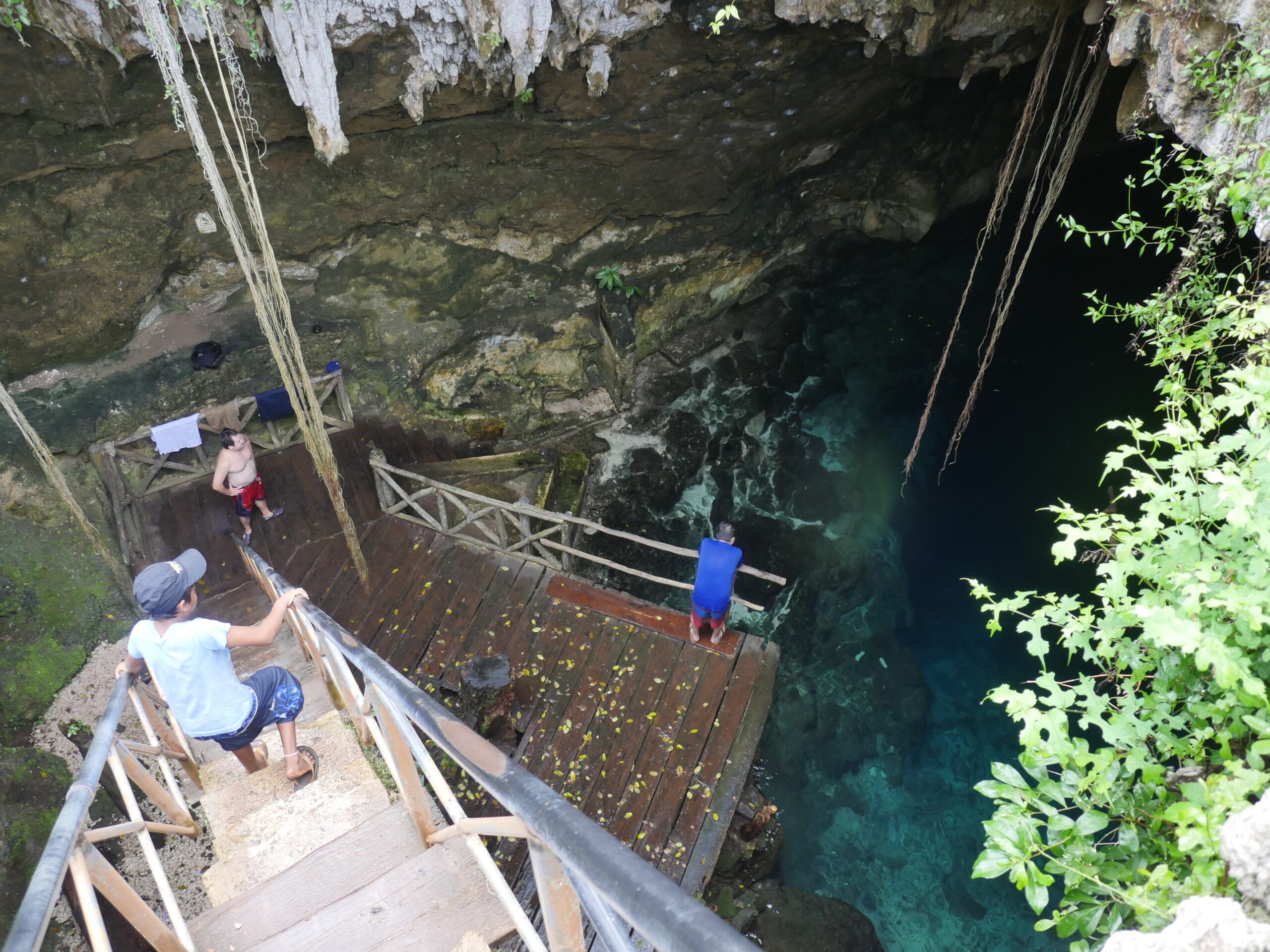 Tourists walk down into a cenote in Cuzamá, Mexico.