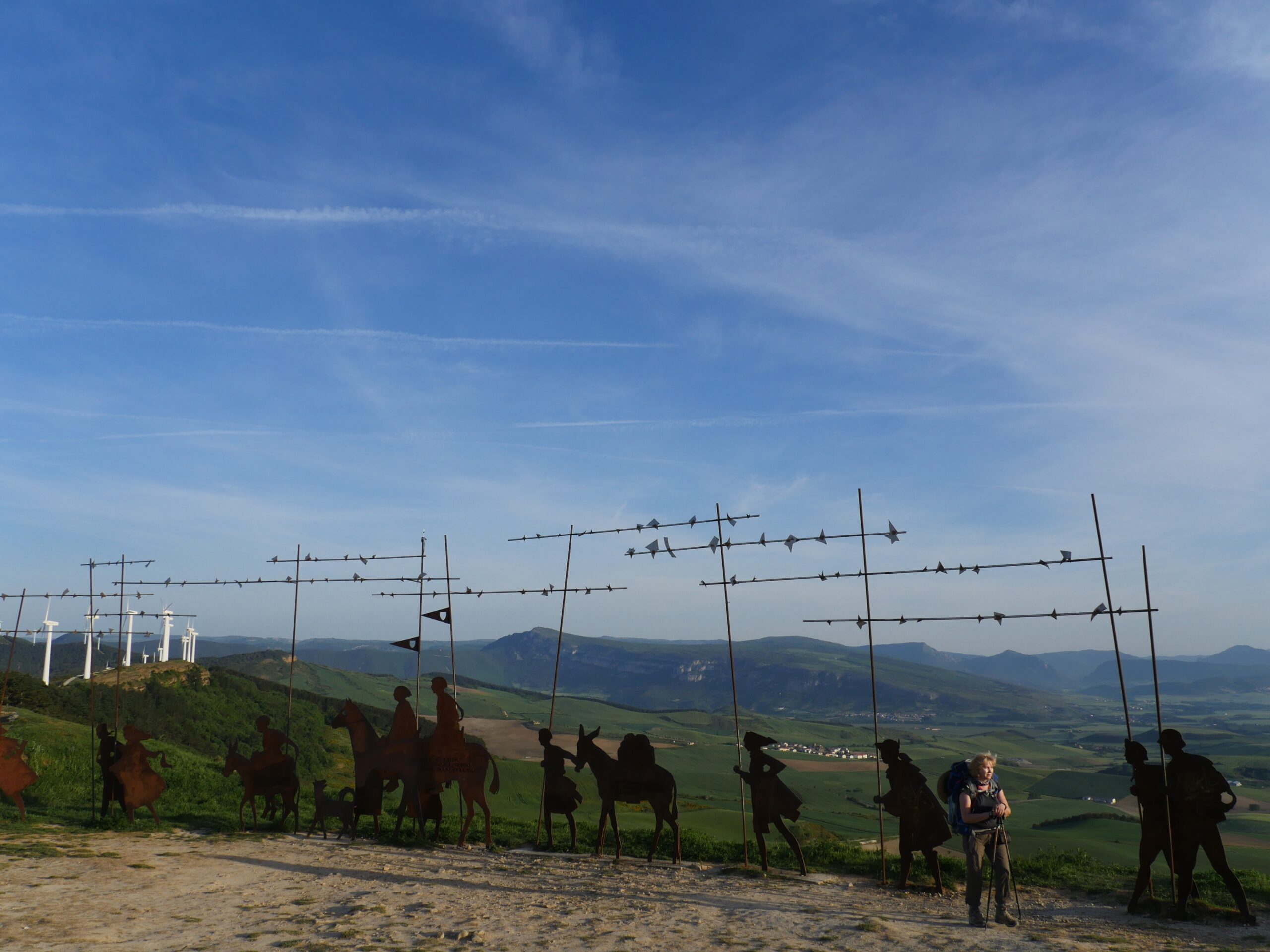 An art installation depicting pilgrims walking the Camino de Santiago sits on a ridge above Zariquiegui, Spain.