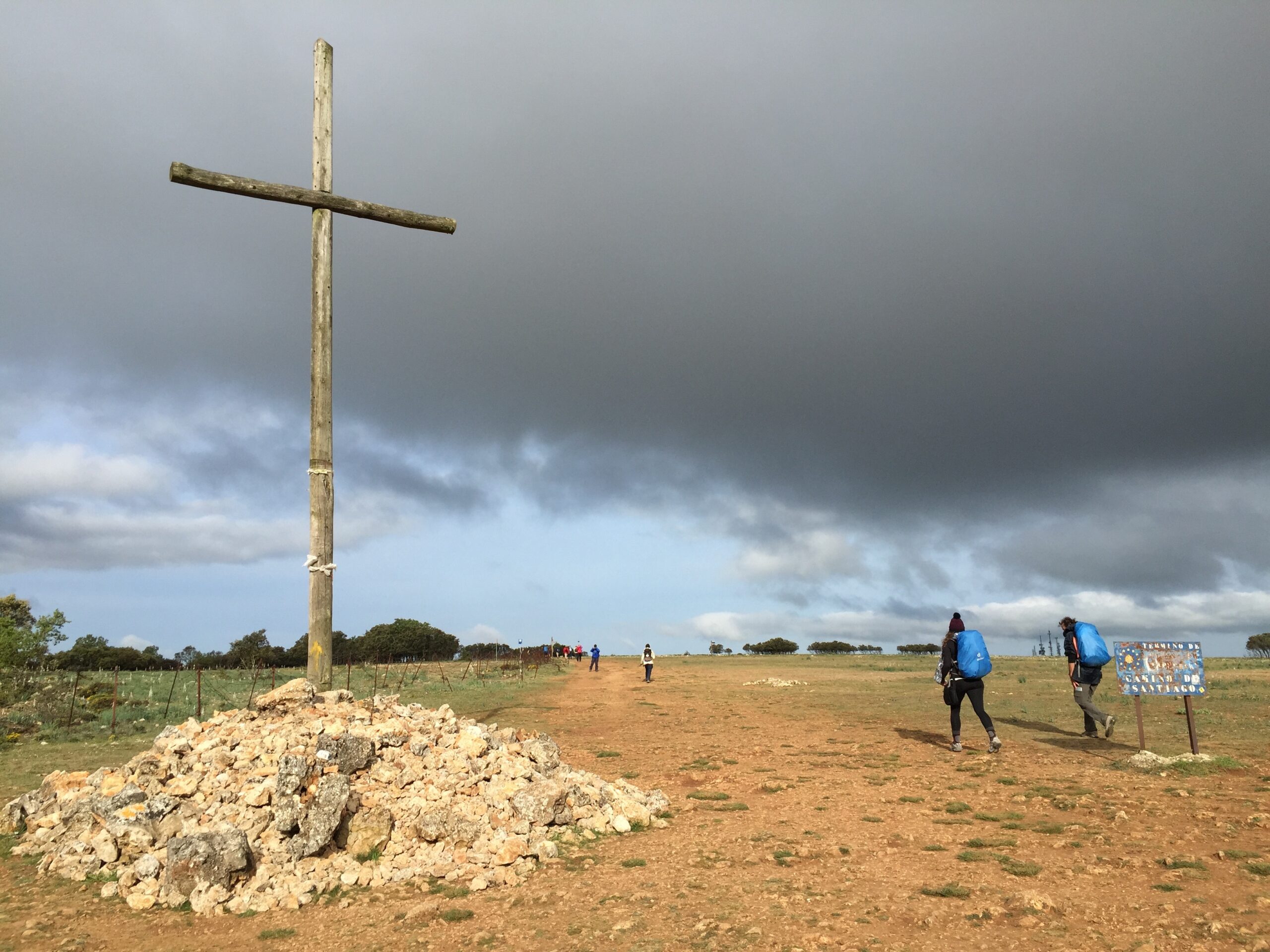 Hikers walk past a wooden cross above Atapuerca, Spain.