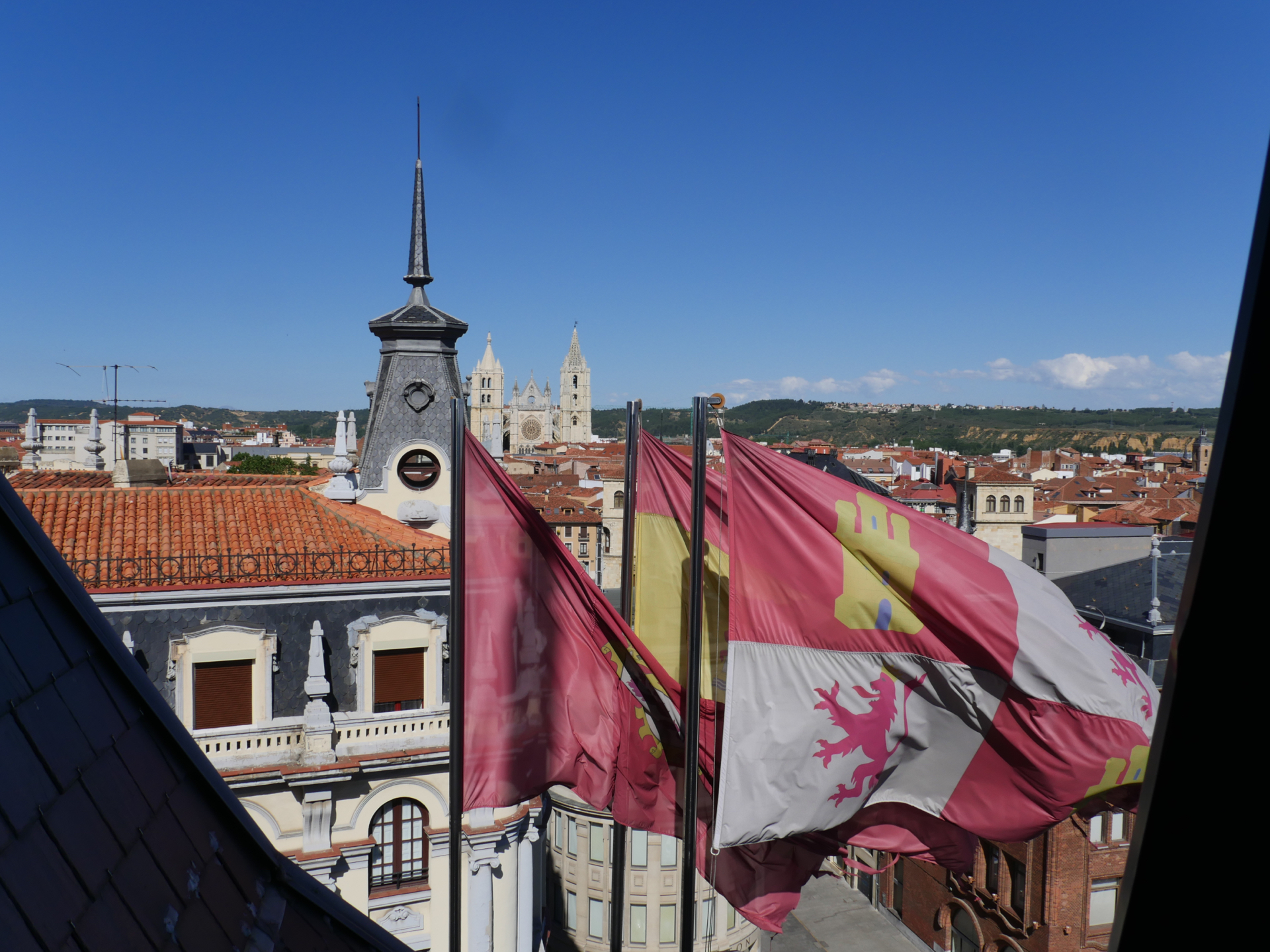 Flags wave in the wind outside a hotel room in León, Spain.