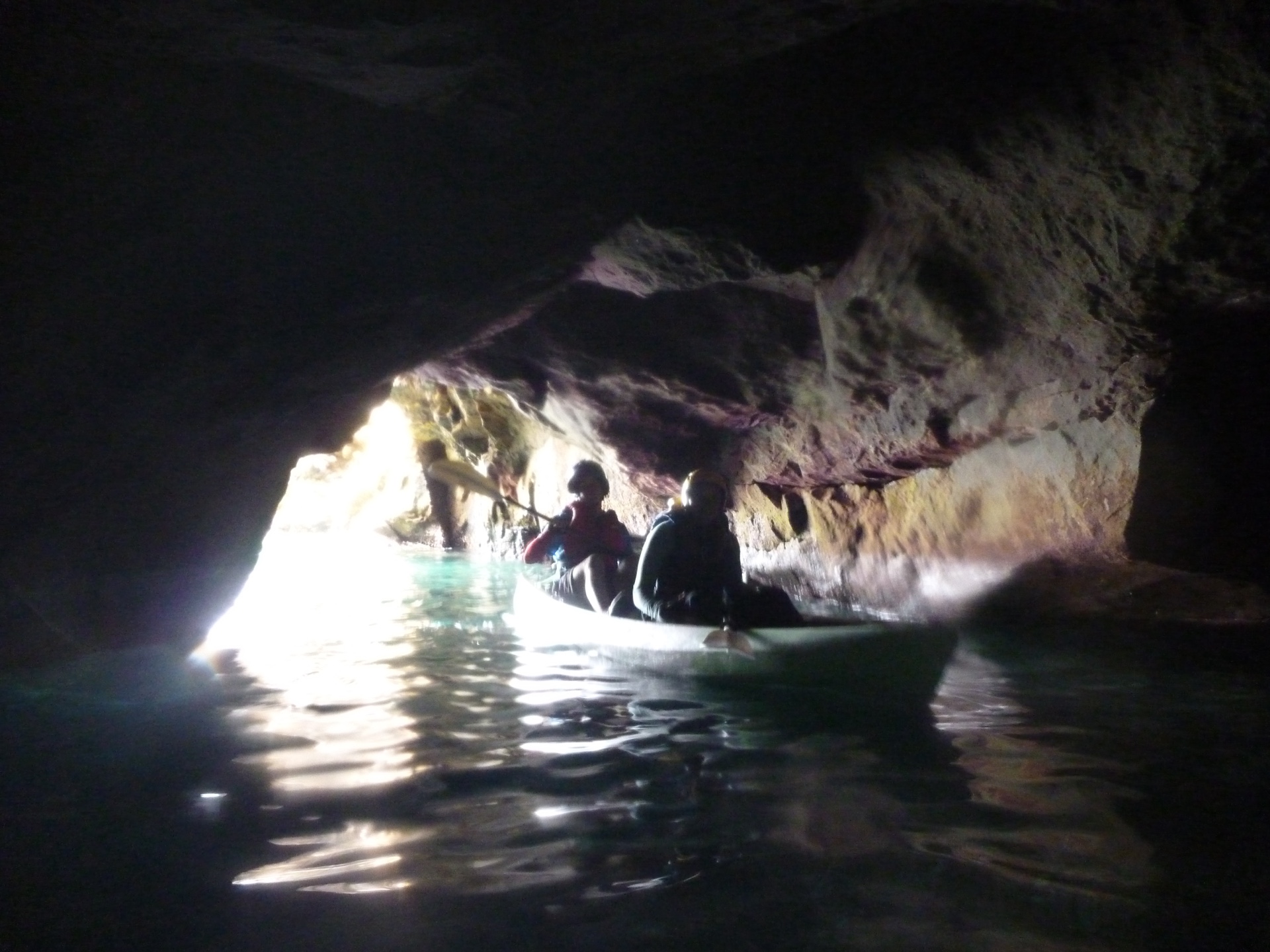 Kayakers paddle into a sea cave near Pelican Bay on Santa Cruz Island, California.
