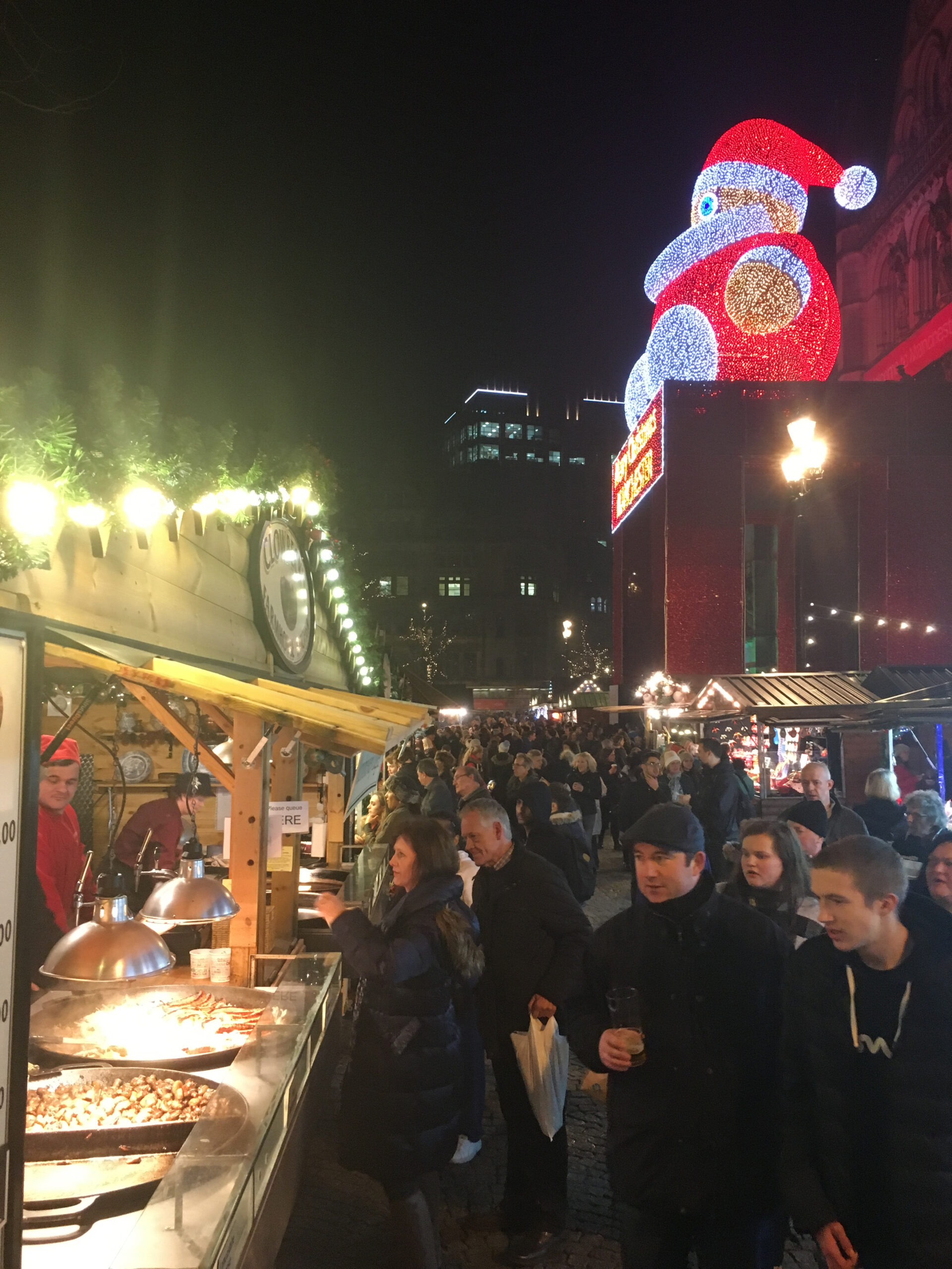 A huge Santa Claus made of lights presides over a Christmas market in Manchester, UK.