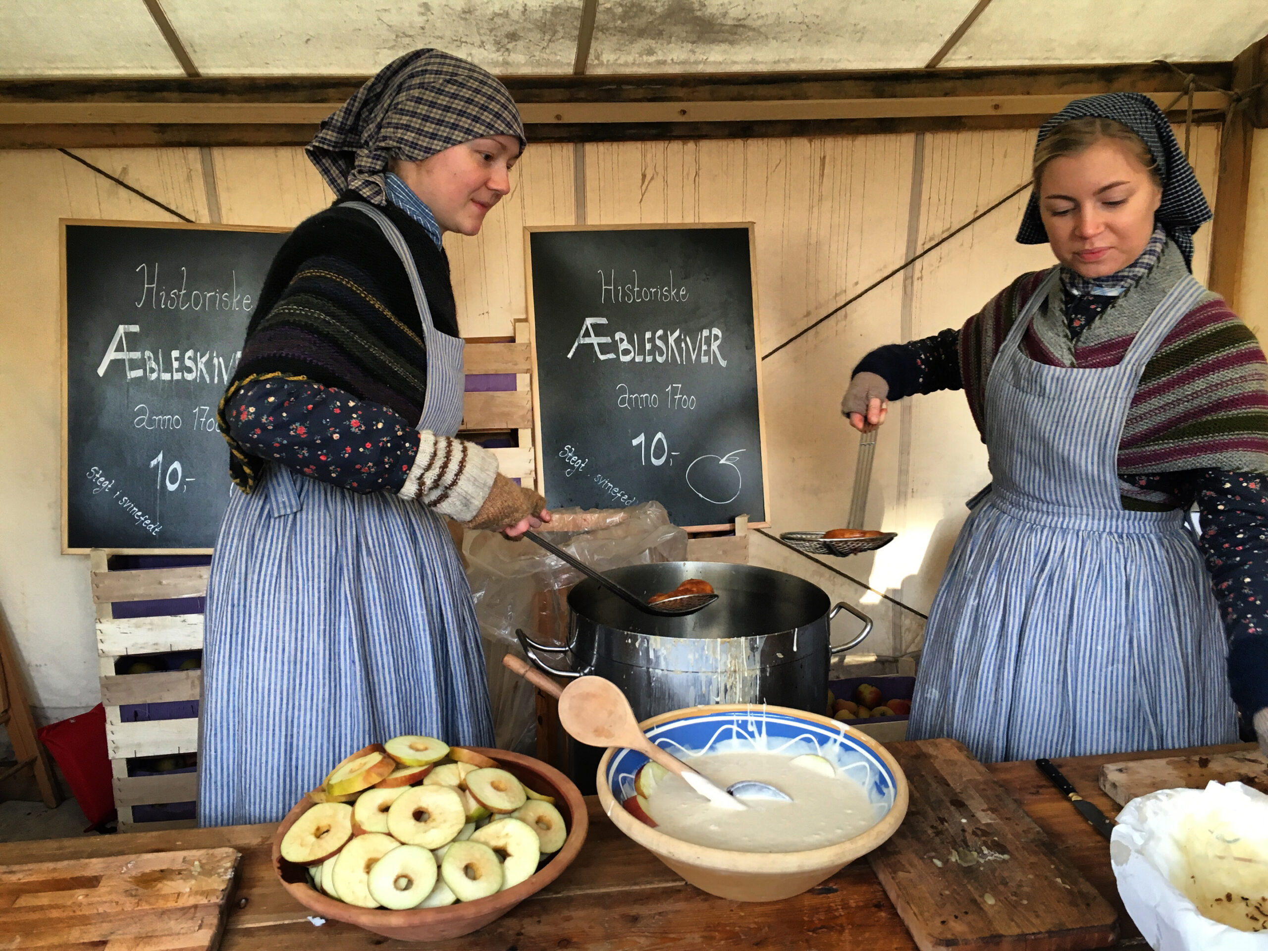 Danish women make Ableskiver, a traditional apple donut made at Christmas time in Den Gamle By, an open-air museum in Aarhus, Denmark.