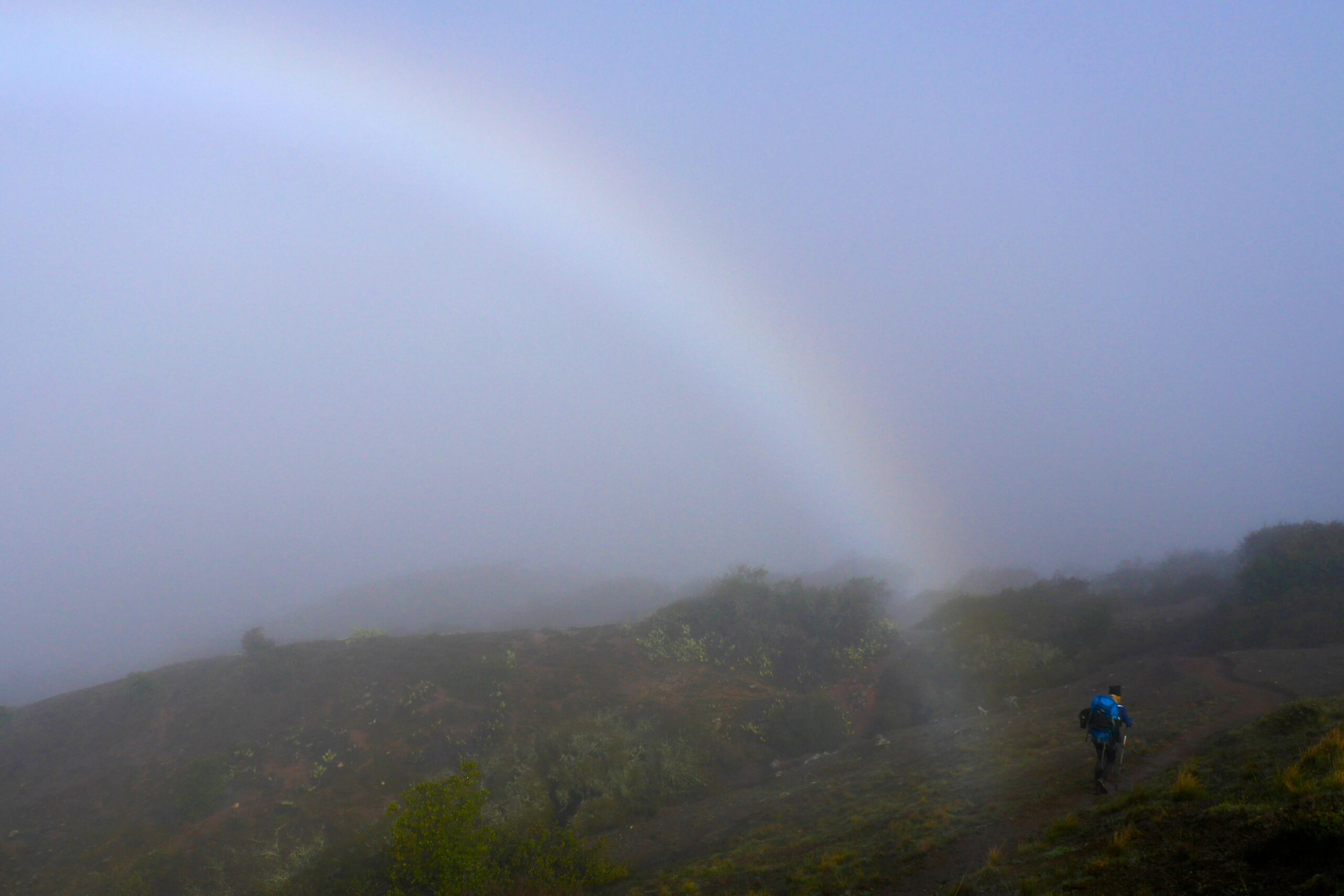 A hiker walks by a morning rainbow on the Trans-Catalina Trail.