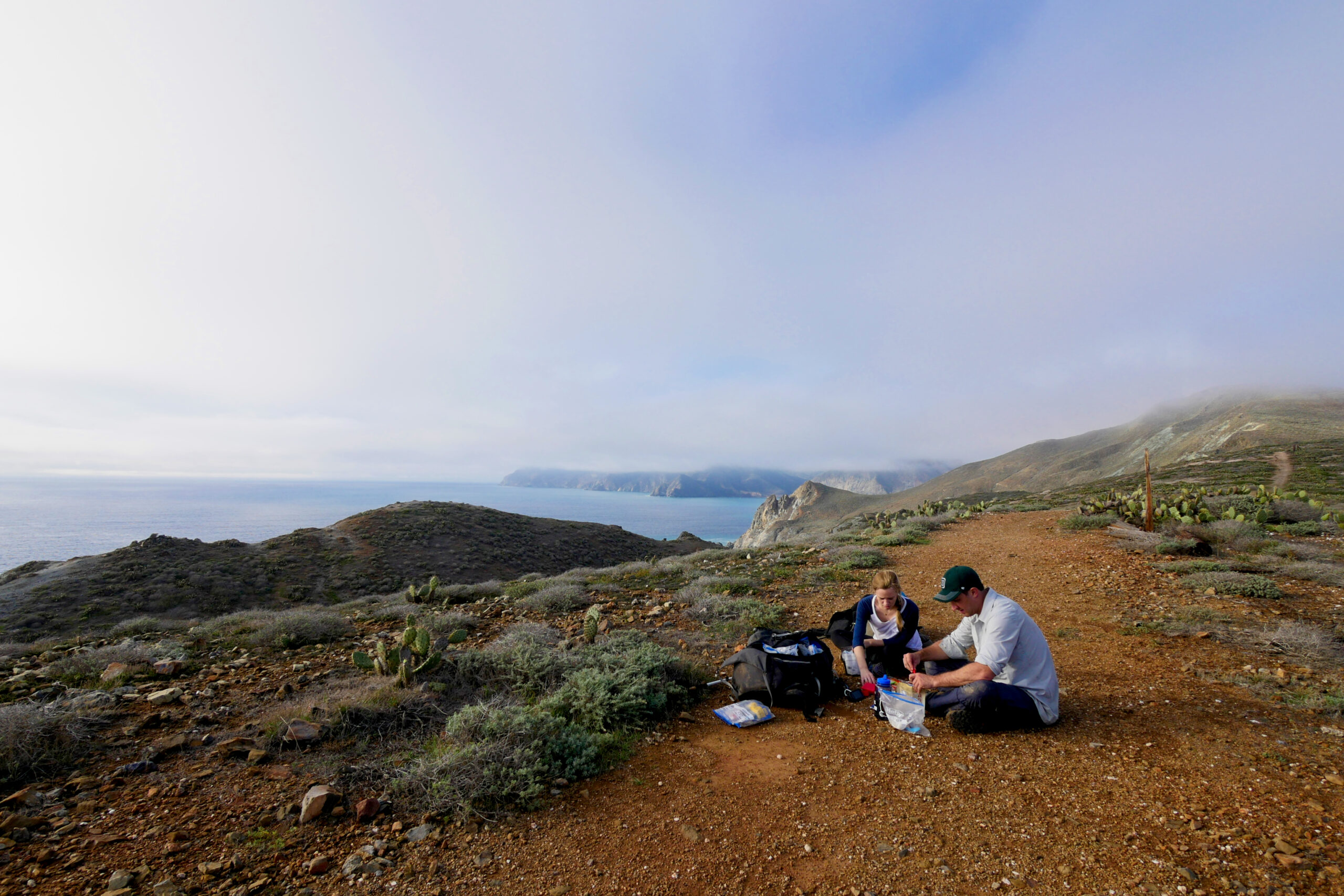 Hikers stop to eat lunch at a viewpoint above Little Harbor on the Trans-Catalina Trail.