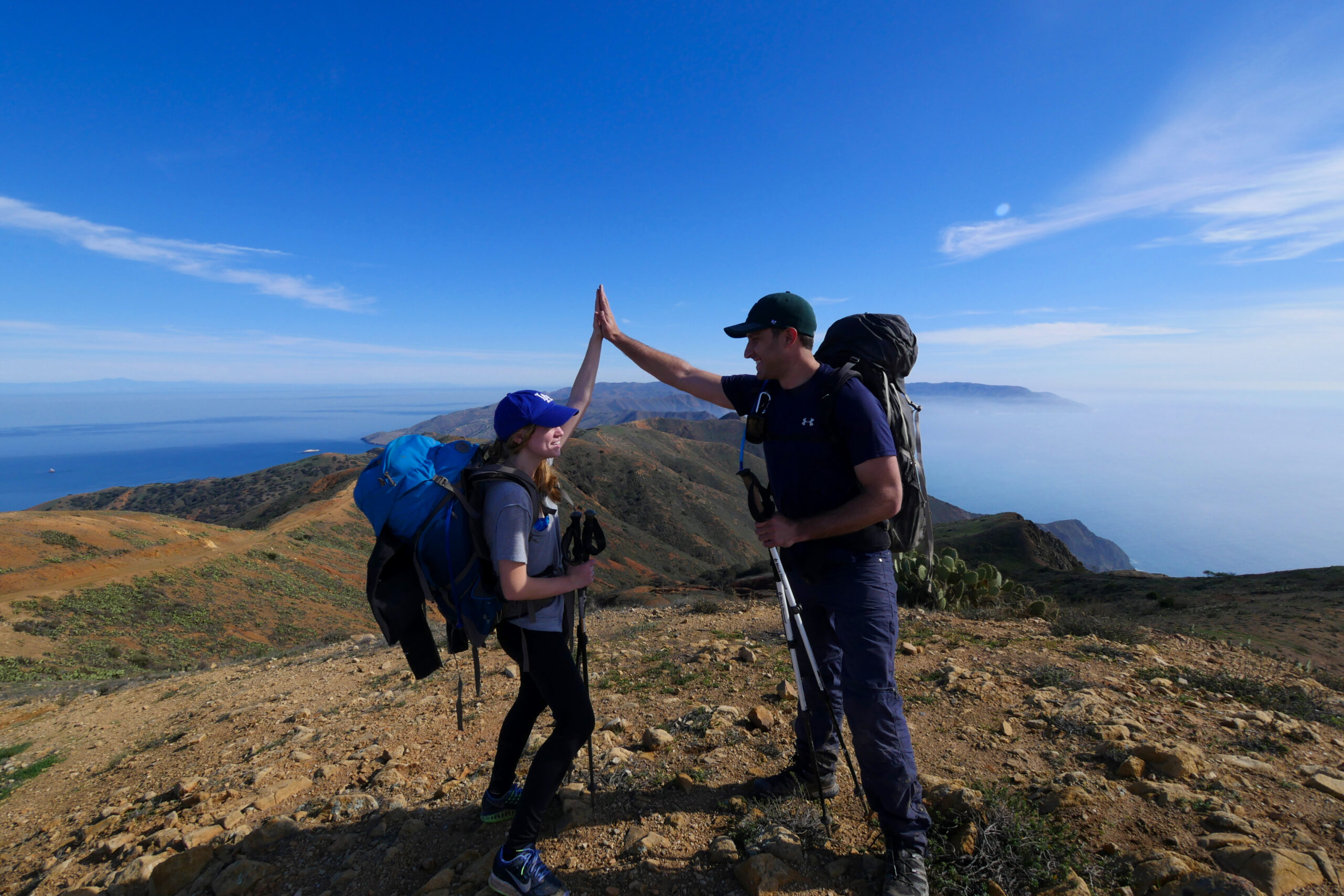 Hikers high-five at the Trans-Catalina Trail's high point at 1,800 feet.