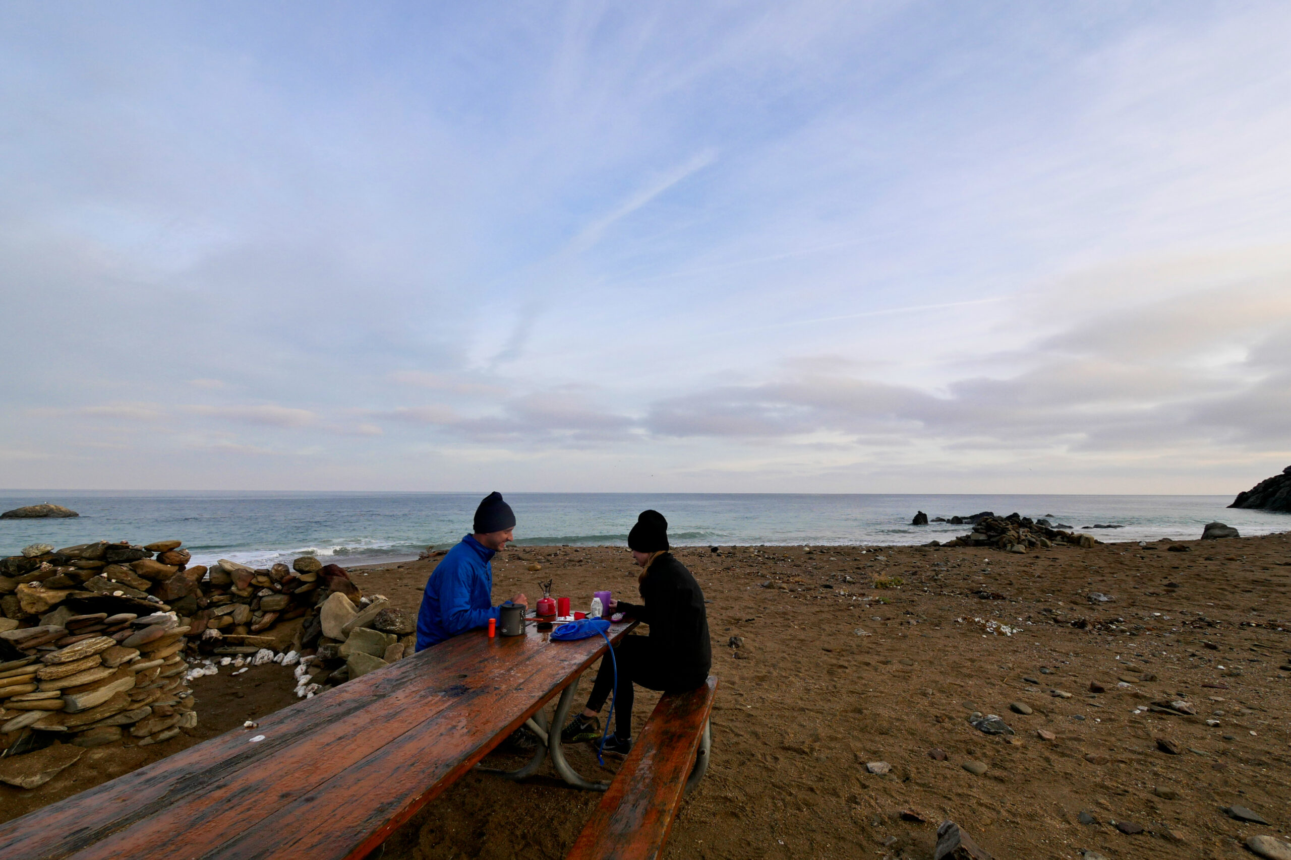 Hikers make coffee in the morning at a picnic table at Parsons Landing on Catalina Island, California.