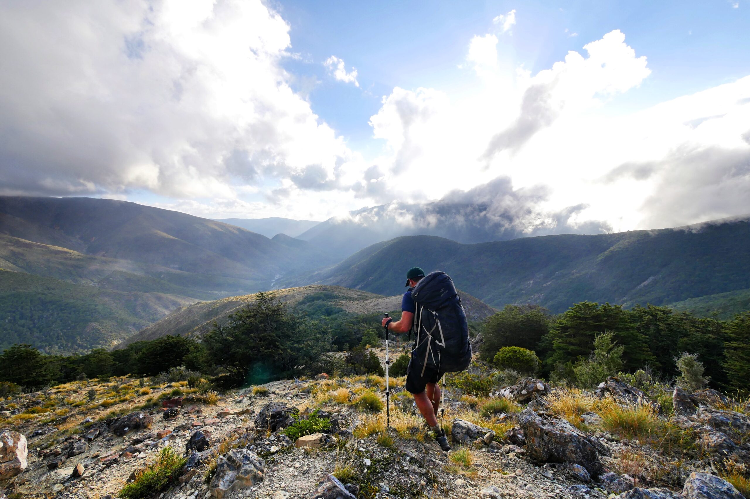 A hiker looks out from a ridge above Slaty Hut in New Zealand's Richmond Range.