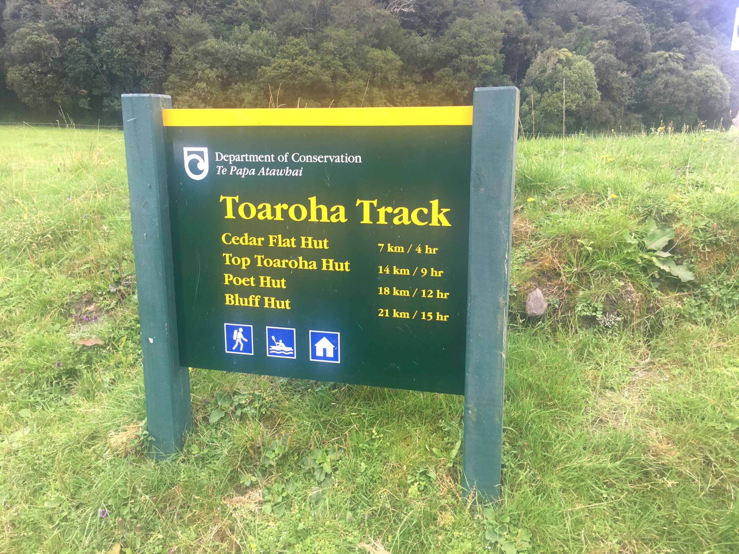 A sign providers hikers with time estimates for the Toaroha Track.