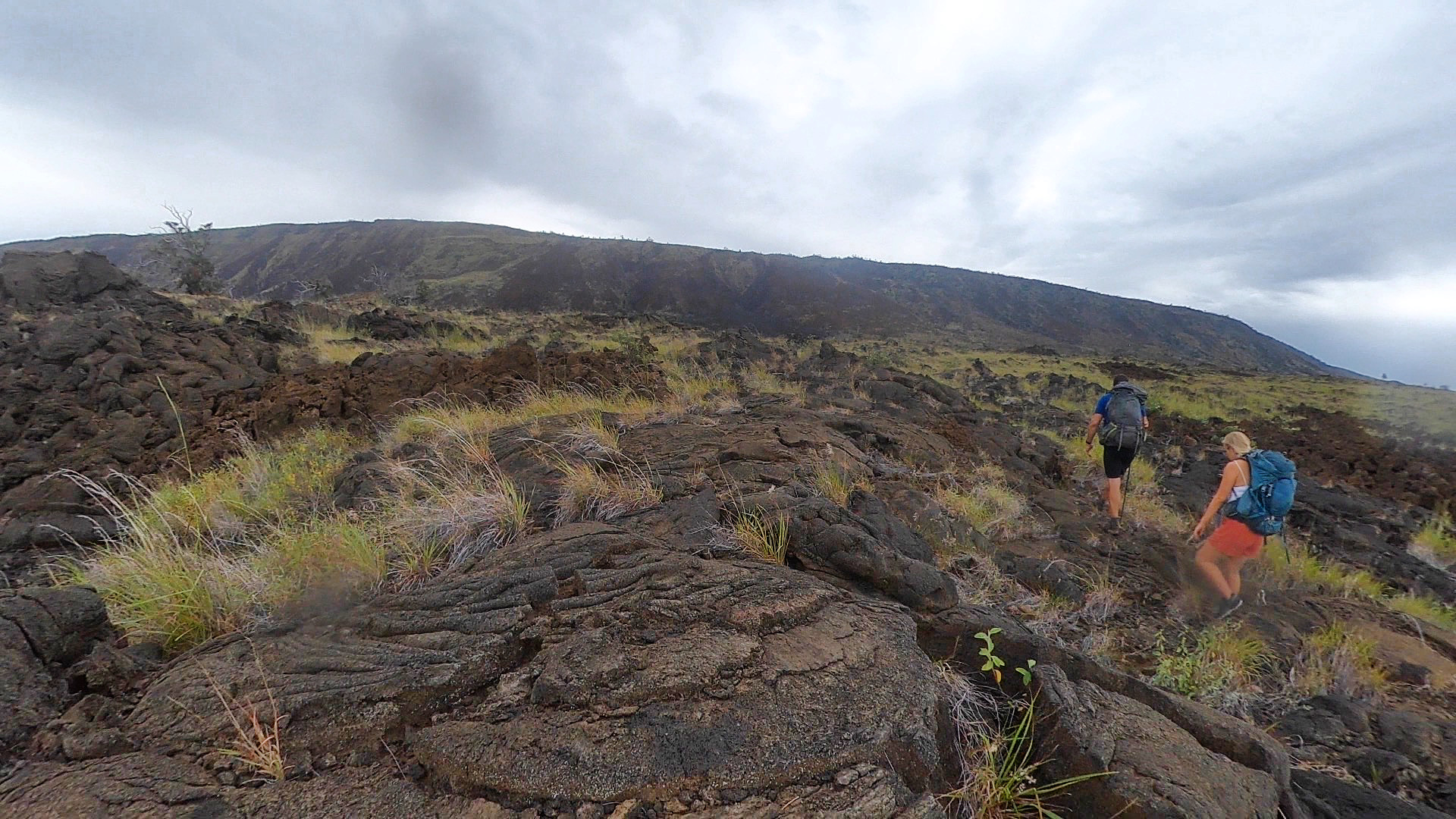 Hikers making their way across lava fields on the Hilina Pali Trail.