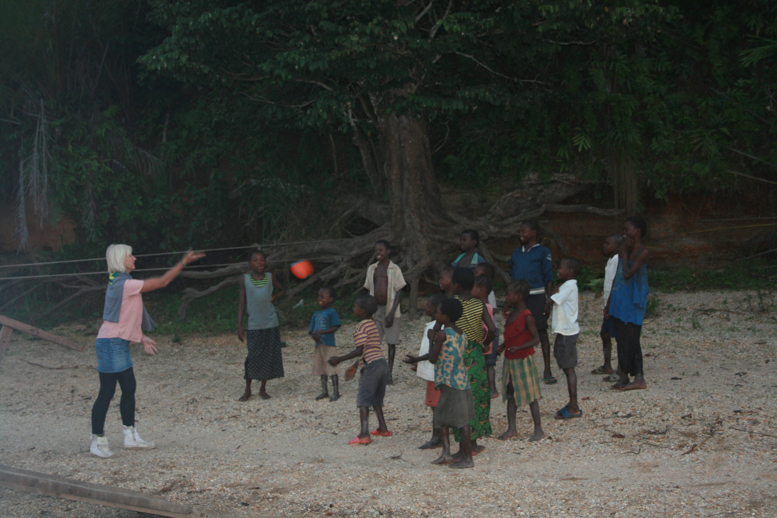 Woman playing dodgeball with Yanonge village children