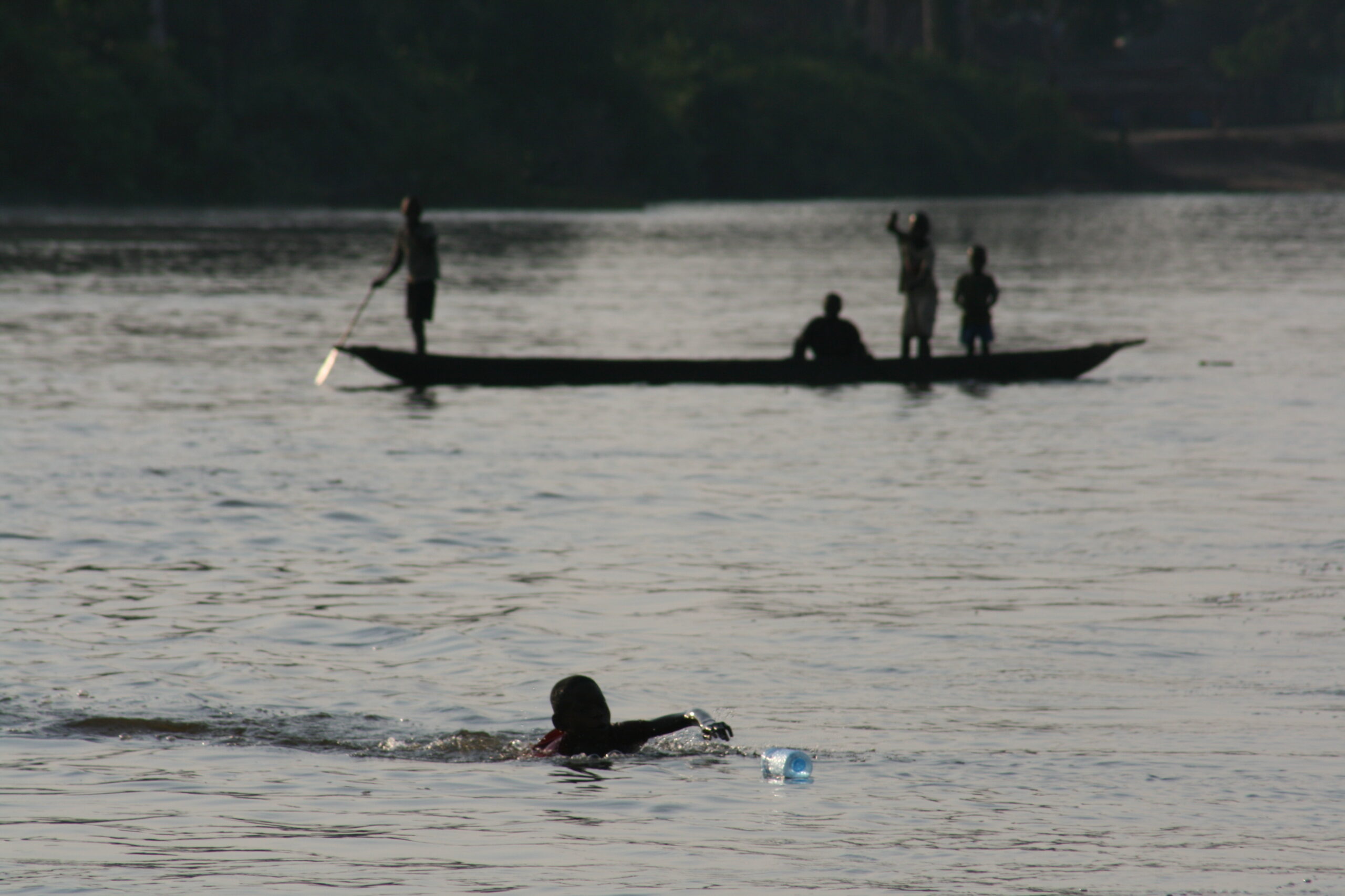 Children racing for water bottles near Bomongo