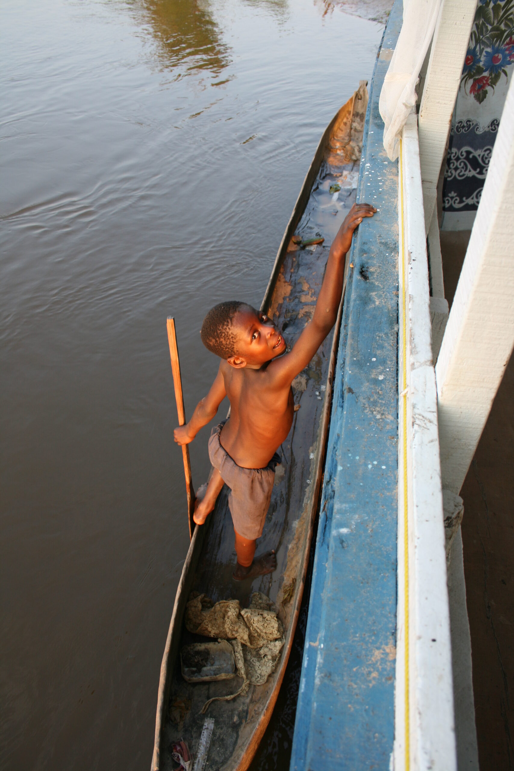 Child holding onto boat near Malonbolombo